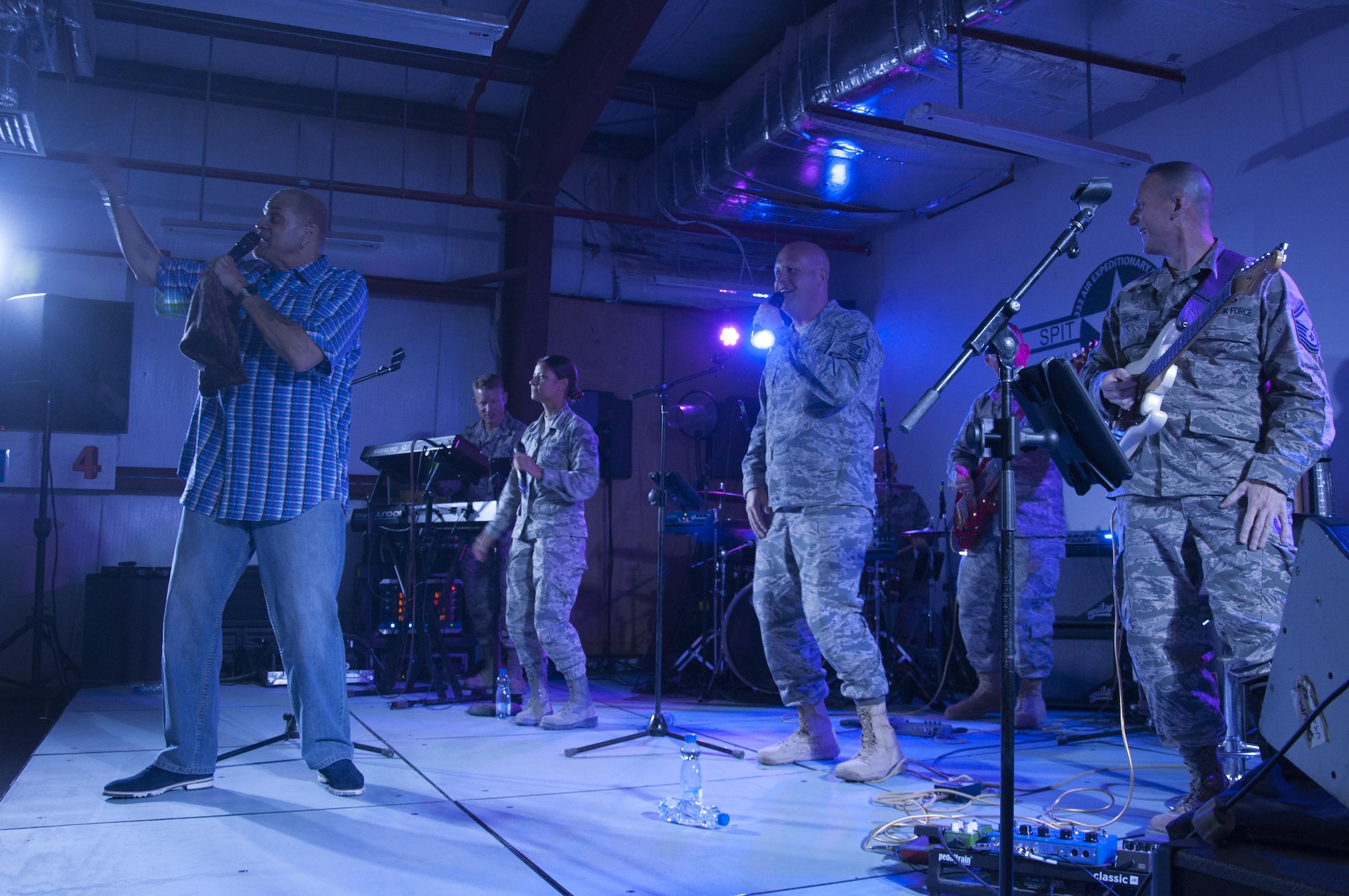 American comedian, Sinbad, and Air Force Central Command band, "Maximum Impact", performs for the troops at an undisclosed location June 12, 2016. The band opened for comedian, Sinbad who toured several bases to perform to help boost morale to deployed members around the theater.(U.S. Air Force photo by Master Sgt. Anika Jones/Released)