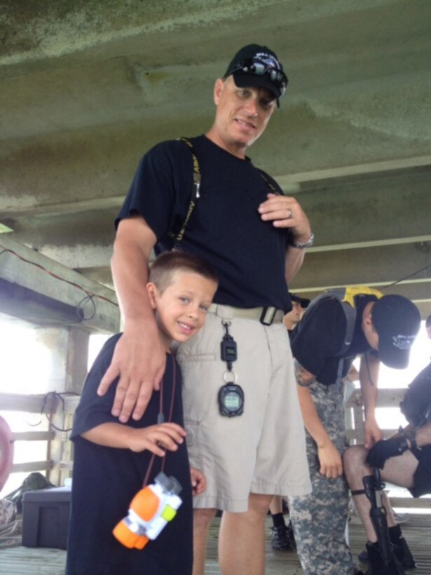 Army Staff Sgt. Shawn G. Dagley of the Texas Army National Guard’s 627th Dive Detachment, 386th Engineer Battalion, 176th Engineer Brigade, poses with his son Gage, left, during a unit dive exercise at the Port of Corpus Christi, Texas, July 27, 2014. During Dagley’s eight years as the dive supervisor, the unit conducted 500 to 600 successful dives with no safety issues. The team cased its colors June 6, 2015. Courtesy photo