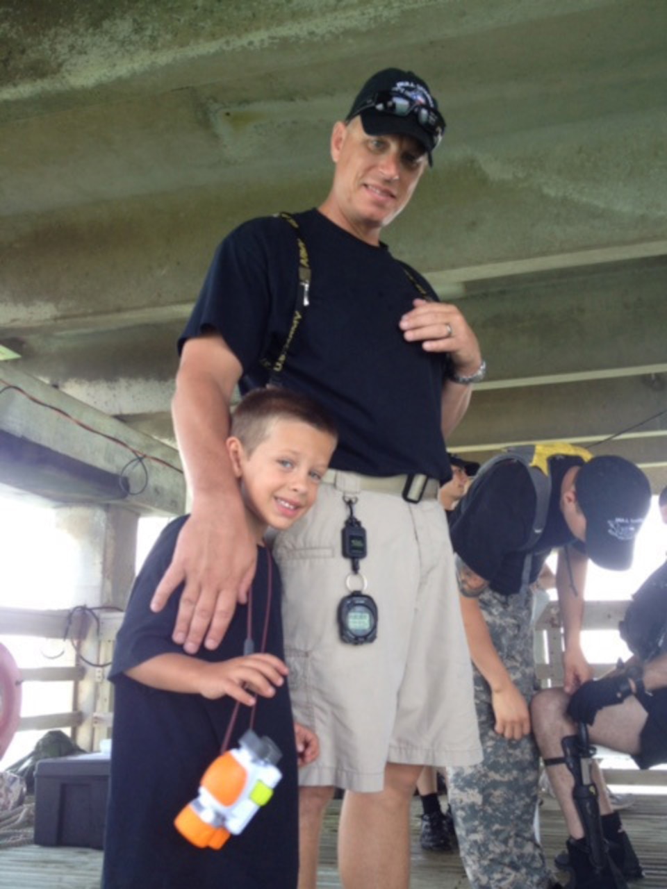 Army Staff Sgt. Shawn G. Dagley of the Texas Army National Guard’s 627th Dive Detachment, 386th Engineer Battalion, 176th Engineer Brigade, poses with his son Gage, left, during a unit dive exercise at the Port of Corpus Christi, Texas, July 27, 2014. During Dagley’s eight years as the dive supervisor, the unit conducted 500 to 600 successful dives with no safety issues. The team cased its colors June 6, 2015. Courtesy photo