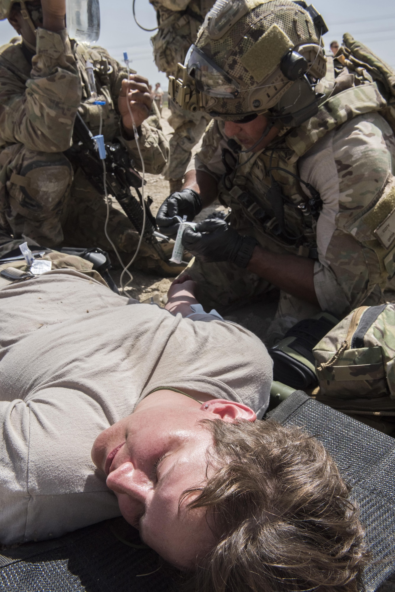 Senior Airmen Coty Polito, 83rd Expeditionary Rescue Squadron pararescue specialist, gives Master Sgt. Paige Frye, 455th Air Expeditionary Wing paralegal, an intravenous solution during a joint mass casualty and extraction exercise, June 16, 2016 at Bagram Airfield, Afghanistan. Airmen from the 455th AEW acted as wounded patients, with injuries that included broken limbs, loss of eye sight and deliria. (U.S. Air Force photo by Tech. Sgt. Tyrona Lawson)
