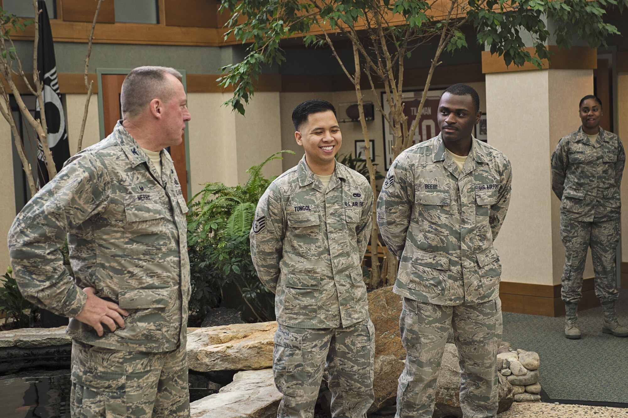 Staff Sgt. Lawrence Tungol, 512th Maintenance Squadron, and Senior Airman Travis Beebe, 512th Memorial Affairs Squadron, are awarded the Air Force Mortuary Affairs Operation Safety Coin from Col. Daniel Merry, AFMAO commander, June 15, 2015, Dover Air Force Base, Del. The two Airmen rushed to a woman stuck inside her vehicle after it overturned when striking another vehicle and assisted her until law enforcement and emergency medical technicians could arrive. (U.S. Air Force Photo/ Tech. Sgt. Nathan Rivard)