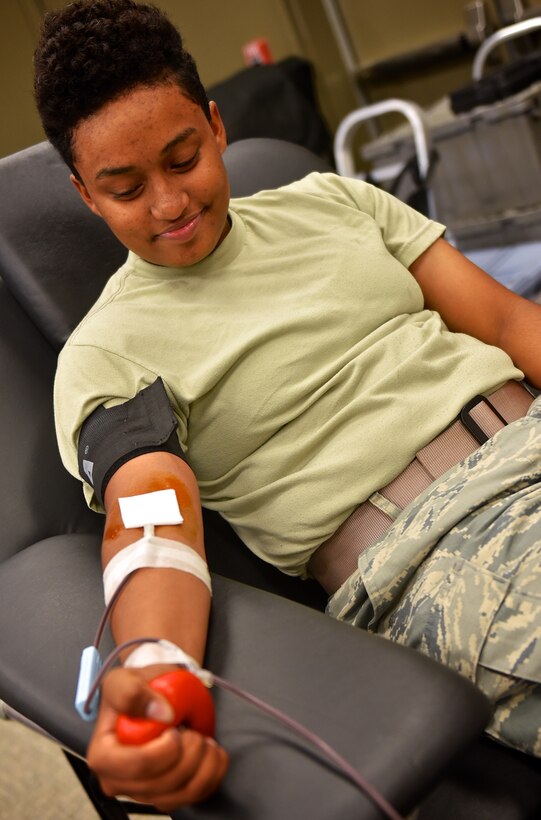 Airman 1st. Class Ashlei Scott, 932nd Security Forces Squadron, slowly squeezes her fist as she watches the process of donating blood with the American Red Cross, June 16, 2016 at the 932nd Airlift Wing building auditorium.  Scott, attending annual tour training at the 932nd, had no hesitations to donate blood and said this was her first time to donate.  "I just want to give back, " said Scott about her reason for donating.  (U.S. Air Force photo by Christopher Parr)