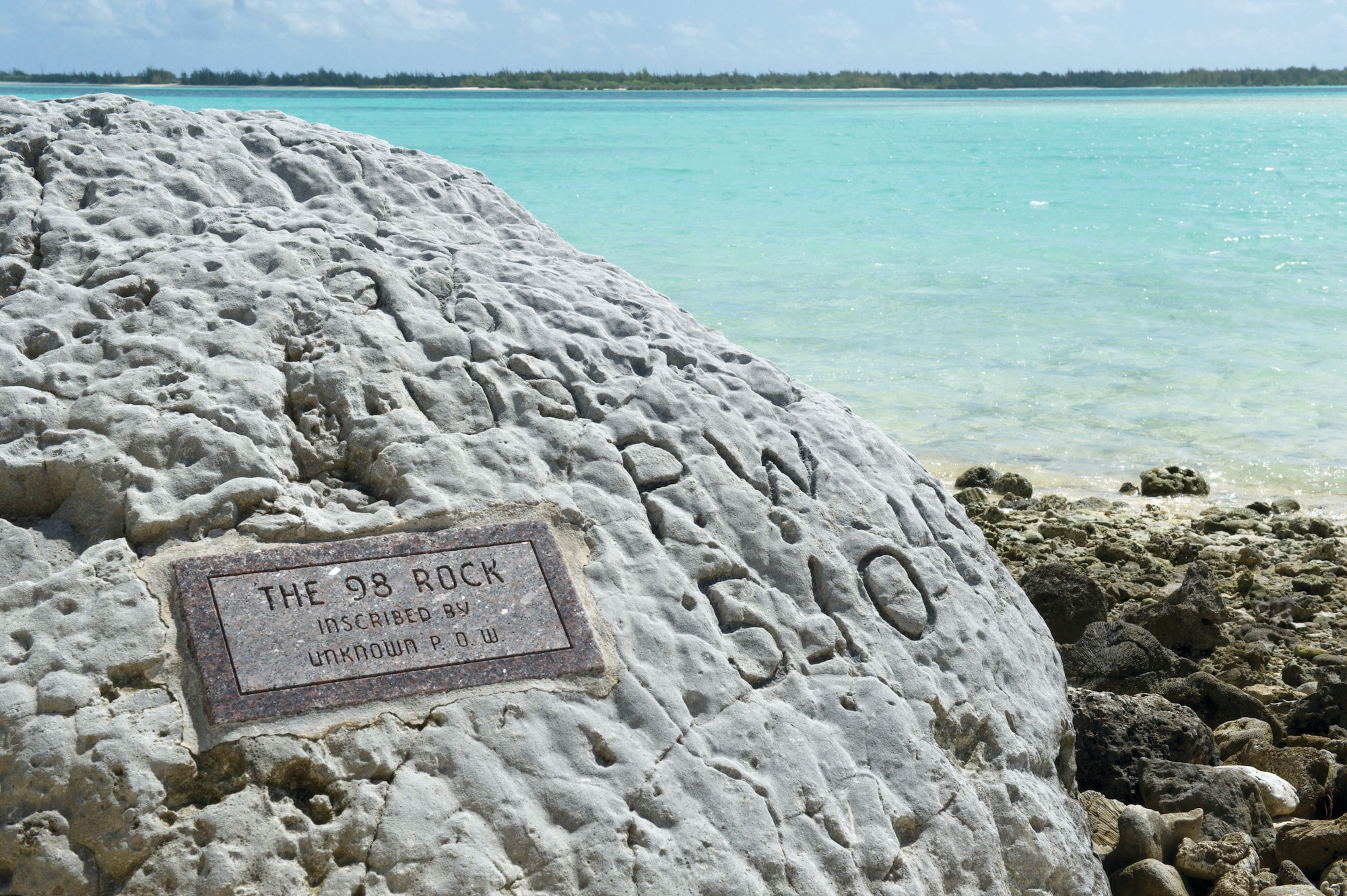 Hand-drawn lettering reading “98 US PW 5-10-43” marks a coral head near the shoreline of the Wake Island lagoon in the mid-Pacific. American forces on the island, led by the U.S. Marine Corps 1st Marine Defense Battalion and aircraft from Marine Attack Squadron 211, held out against Japanese assaults for 15 days. Nearly 1,200 civilian workers, racing to develop the island’s airfield in the closing months of 1941, were on the island and participated in the battle. The Americans surrendered on December 23 and 98 of the civilian workers of Wake were kept on the island to aid the Japanese with heavy equipment operation. The “98” were executed by the Japanese on October 5, but an unknown worker escaped and inscribed the event in rock before he was recaptured. The final member of the 98 was personally executed by Japanese Rear Admiral Shigematsu Sakaibara, who was later convicted of and hanged for war crimes in a 1947 tribunal. (U.S. Air Force photos/1st Lt. Michael Trent Harrington)