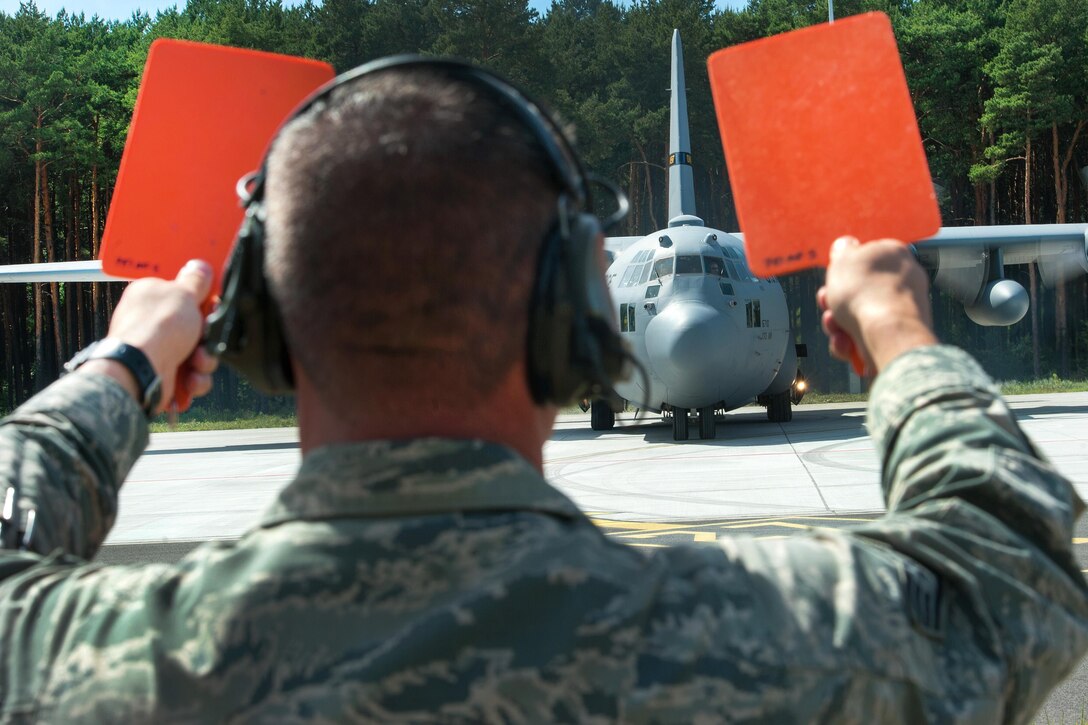 Air Force Staff Sgt. Curtis Crawford marshals a C-130J Super Hercules aircraft during Exercise Swift Response 16 at the Bydgoszcz Airport, Poland, June 9, 2016. Crawford is a loadmaster assigned to the 512th Airlift Control Flight. Air Force photo by Master Sgt. Joseph Swafford