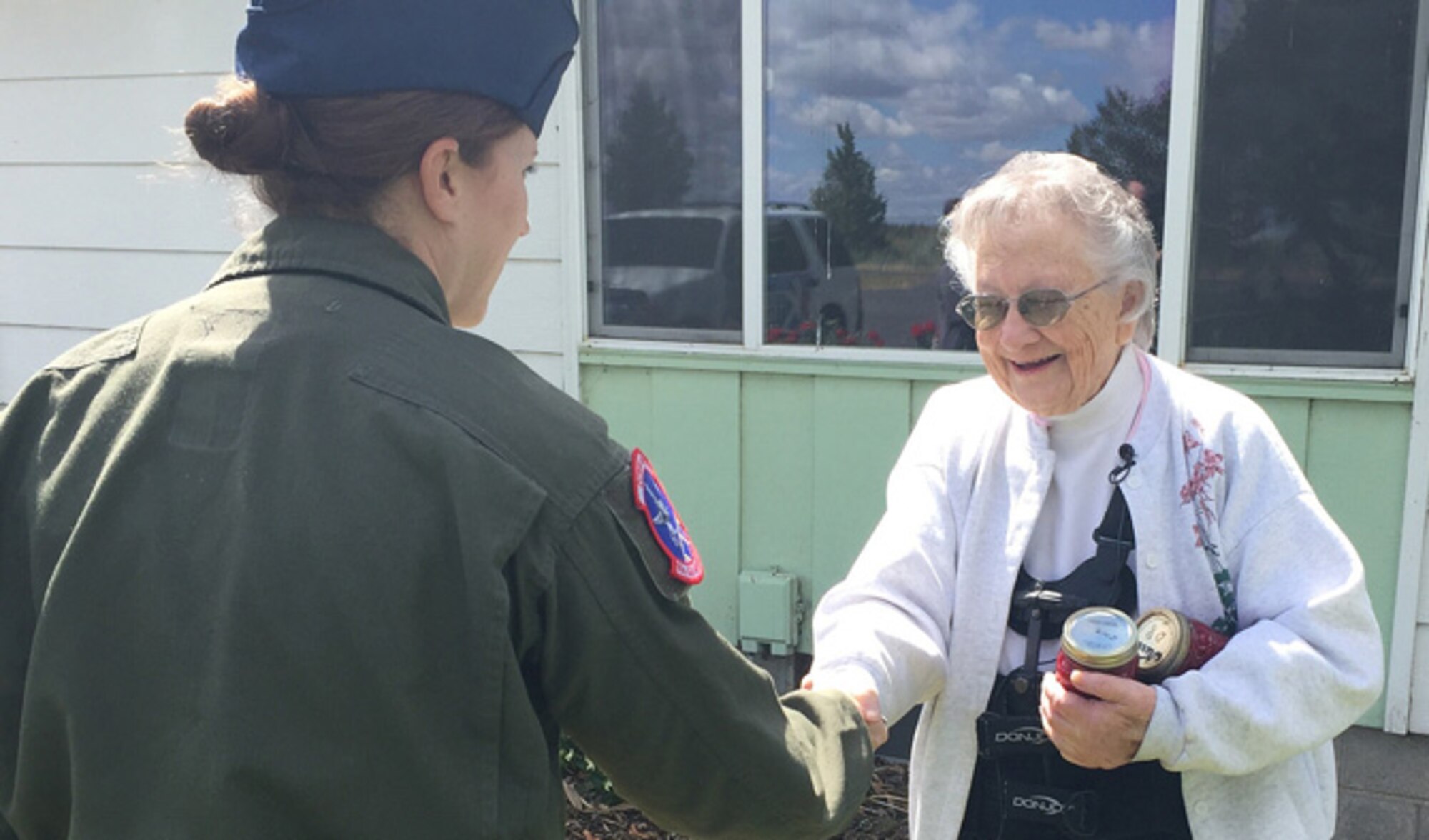 Tech. Sgt. Evangeline Evanzia, 93rd Air Refueling Squadron instructor boom operator, and Krem 2 News surprised Warden, Wash. native, Pat Rogers, to thank her for her contributions to the Treats 2 Troops program June 14, 2016. Since the start of the program 2011, Treats 2 Troops has sent more than 1,500 care packages to Fairchild Airmen serving overseas.(U.S. Air Force photo/Airman 1st Class Mackenzie Richardson)