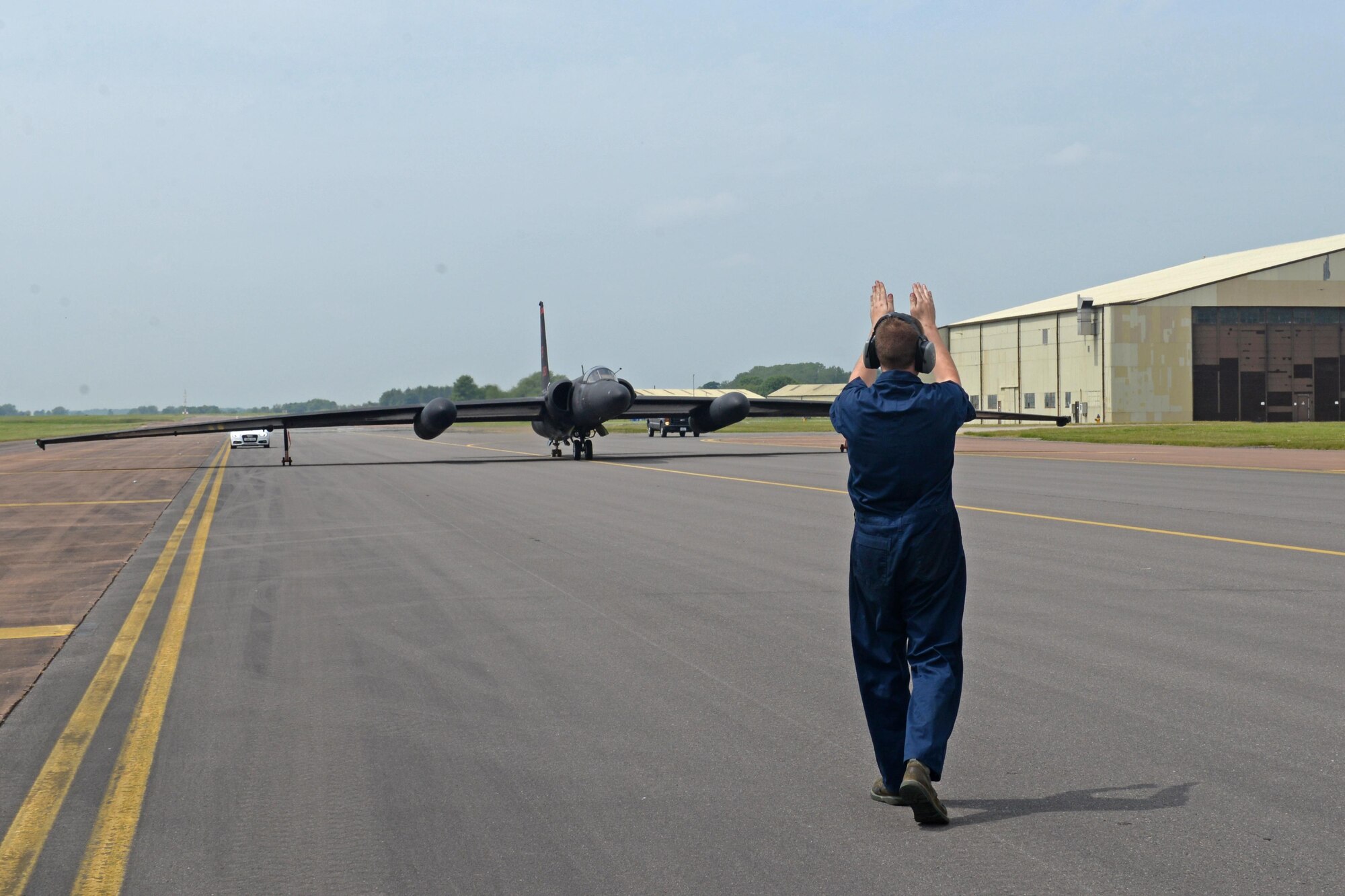 Staff Sgt. Jason Creese, 9the Aircraft Maintenance Squadron U-2 Dragon Lady dedicated crew chief, guides a U-2 Dragon Lady to park June 7, 2016, at Royal Air Force Fairford, Gloucestershire, England. The jet was met by an en route recovery team (ERT) in England to transition aircraft from and to Beale Air Force Base, California, and forward operating locations (FOL). The ERT is used like a pit crew at the midway point in Fairford, ensuring the aircraft are prepared to make it to their next destination. (U.S. Air Force photo by Senior Airman Ramon A. Adelan)