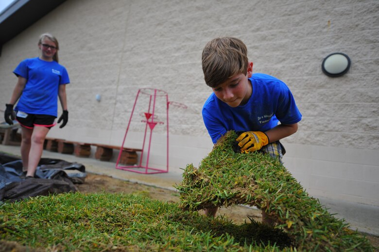A child with Hurlburt Field’s Special Operations Youth Group grabs a block of sod outside the Child Development Center East at Hurlburt Field, Fla., June 16, 2016. The youth group raised a $15,000 budget, which funded a wide range of projects, both on- and off-base. (U.S. Air Force photo by Airman 1st Class Joseph Pick)