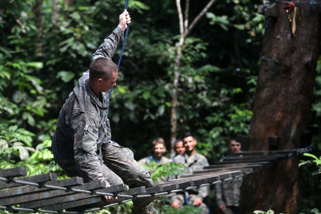 A soldier falls off a wooden bridge obstacle at the French jungle warfare school in Gabon, June 7, 2016. Army photo by Sgt. Henrique Luiz de Holleben