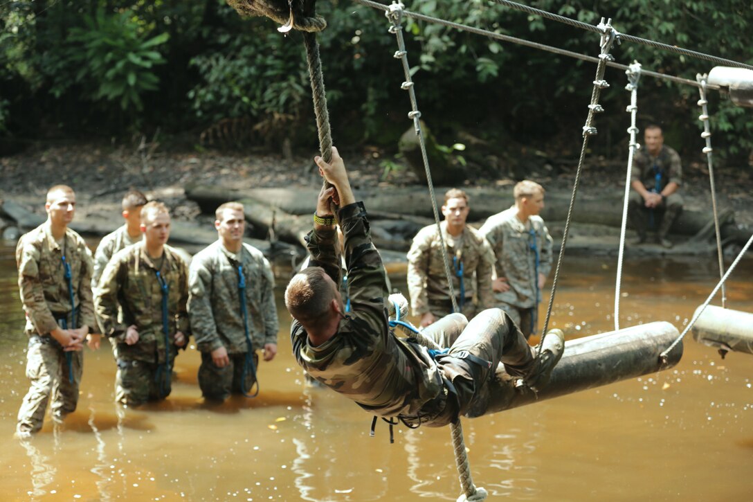 Soldiers observe a French army instructor navigating a water obstacle at the French jungle warfare school in Gabon, June 7, 2016. Army photo by Cpl. Yvette Zabala-Garriga