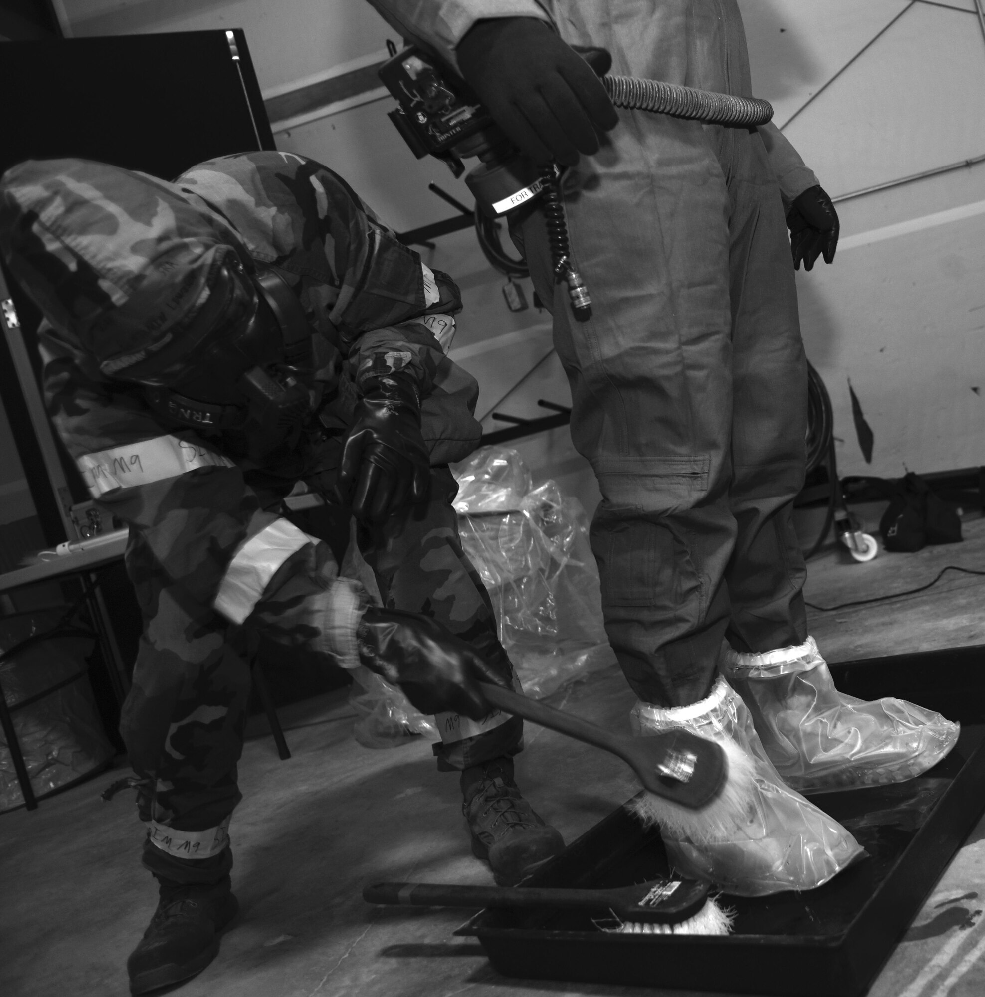 An aircrew flight equipment specialist scrubs off simulated contaminants during the "final exam" phase of an Air Staff exerise rehearsing deployed decontamination processes. Air Force Special Operations Command’s operations directorate ran a realistic, scenario-based, training program for 16 Airmen from eight southern United States bases. (U.S. Air Force photo / Staff Sgt. Melanie Holochwost)