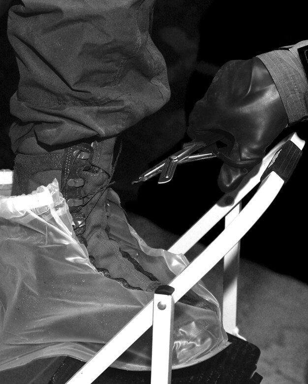 During the "final exam" of the Air Force-level aircrew decontamination exercise June 9 at Hurlburt Field, Fla., a team of aircrew flight equipment Airmen assisted aircrew members through a full-scale contamination control area. The exercise here provided training for the individuals on the equipment and procedures as if they are operating from a forward operating location. (U.S. Air Force photo / Staff Sgt. Melanie Holochwost)