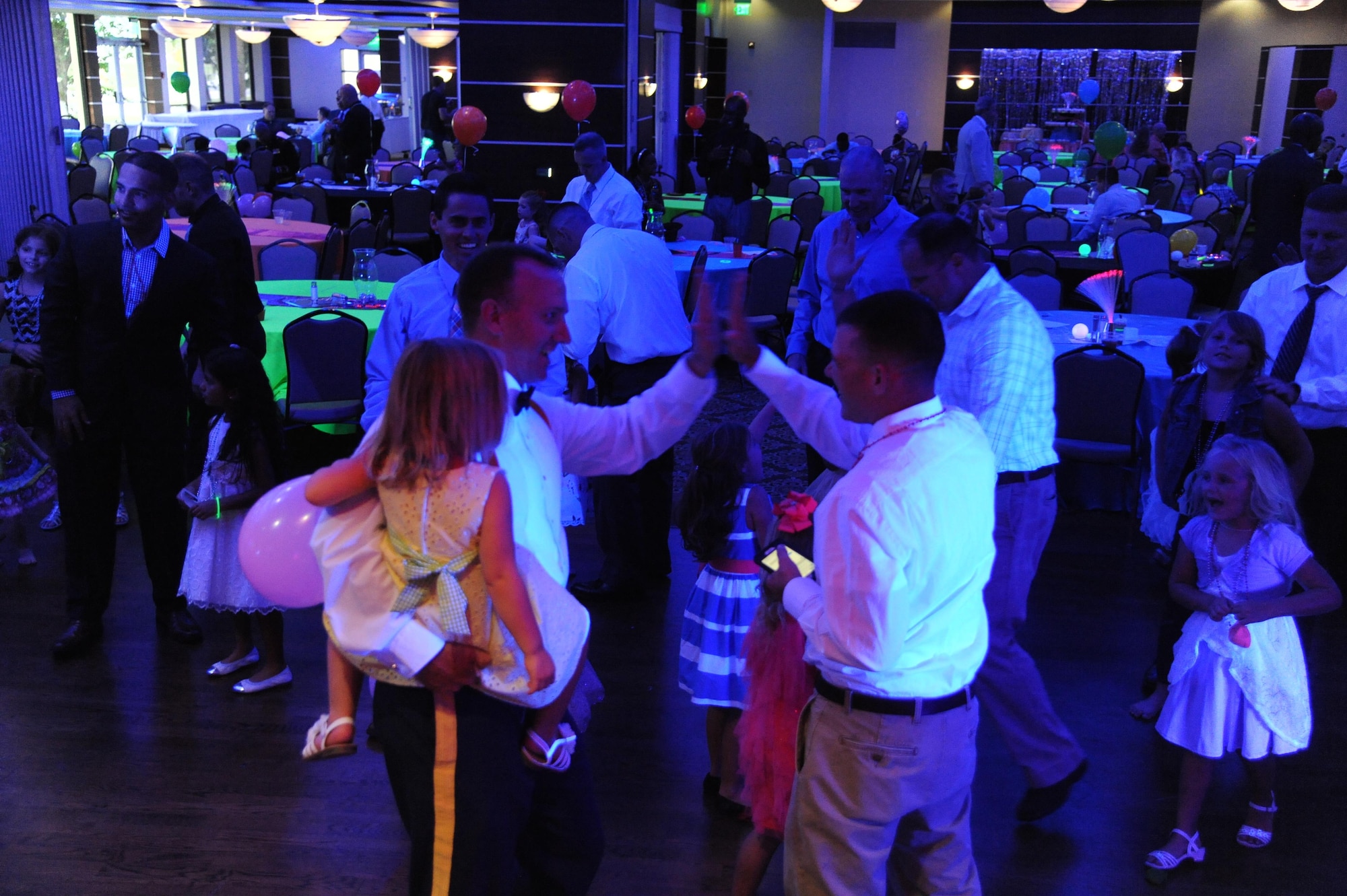 Fathers celebrate after a game during the Daddy/Child dance on MacDill Air Force Base, Fla., June 11, 2016. The dance allowed fathers and their children to come together and enjoy an event for Father’s Day. (U.S. Air Force photo by Airman Adam R. Shanks)