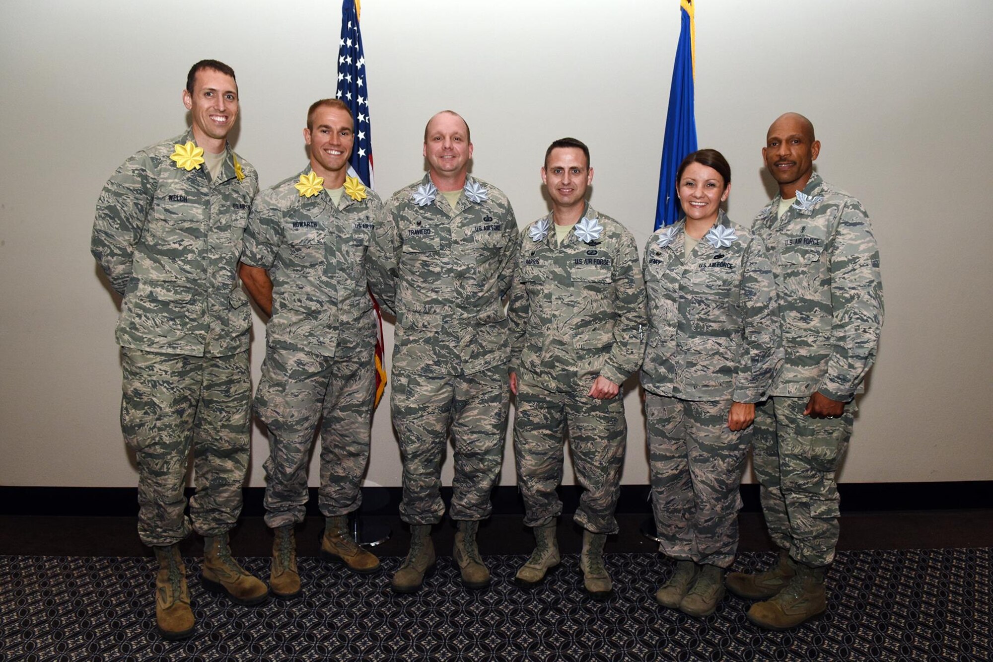 Wearing over-sized novelty ranks, new major, lieutenant colonel and colonel selects stand for a group photo at the Event Center on Goodfellow Air Force Base, June 16, 2016. The 17th Training Wing hosted a recognition ceremony to honor them for their accomplishment. (U.S. Air Force photo by Staff Sgt. Laura R. McFarlane/Released) 