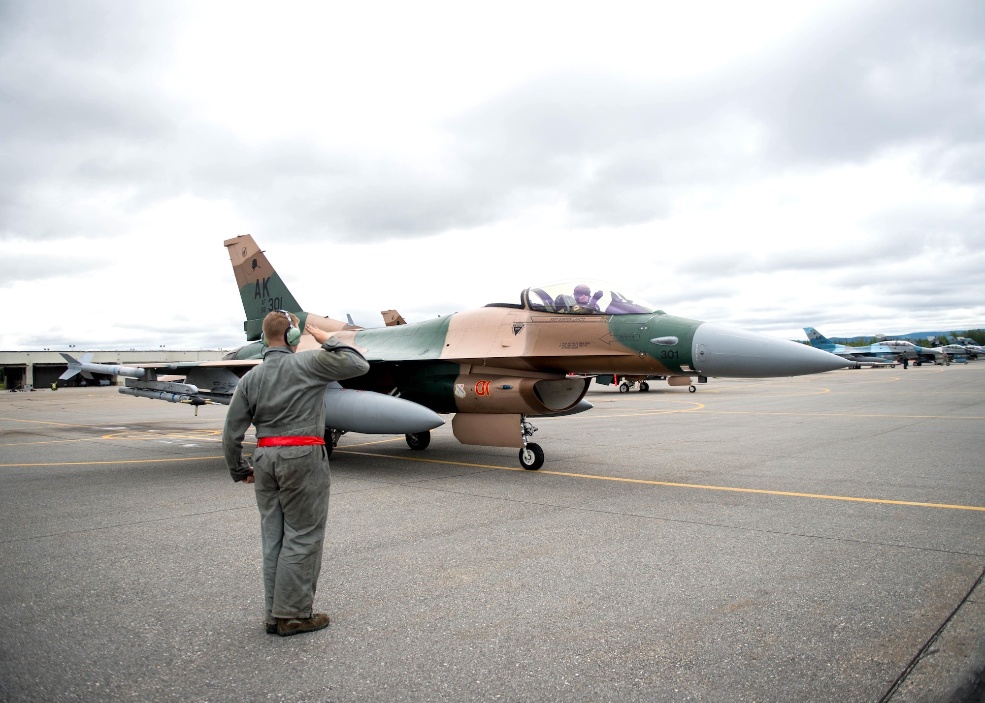 A U.S. Air Force crew chief with the 354th Aircraft Maintenance Squadron salutes Maj. Brian Bragg, the 18th Aggressor Squadron (AGRS) assistant director of operations, prior to the pilot’s take off in a F-16 Fighting Falcon fighter aircraft for a sortie June 14, 2016, during RED FLAG-Alaska (RF-A) 16-2 at Eielson Air Force Base, Alaska. The 18th AGRS participation in RF-A and similar exercises signifies continued commitment to peace, stability and alignment in the Indo-Asia-Pacific region. (U.S. Air Force photo by Staff Sgt. Shawn Nickel/Released)
