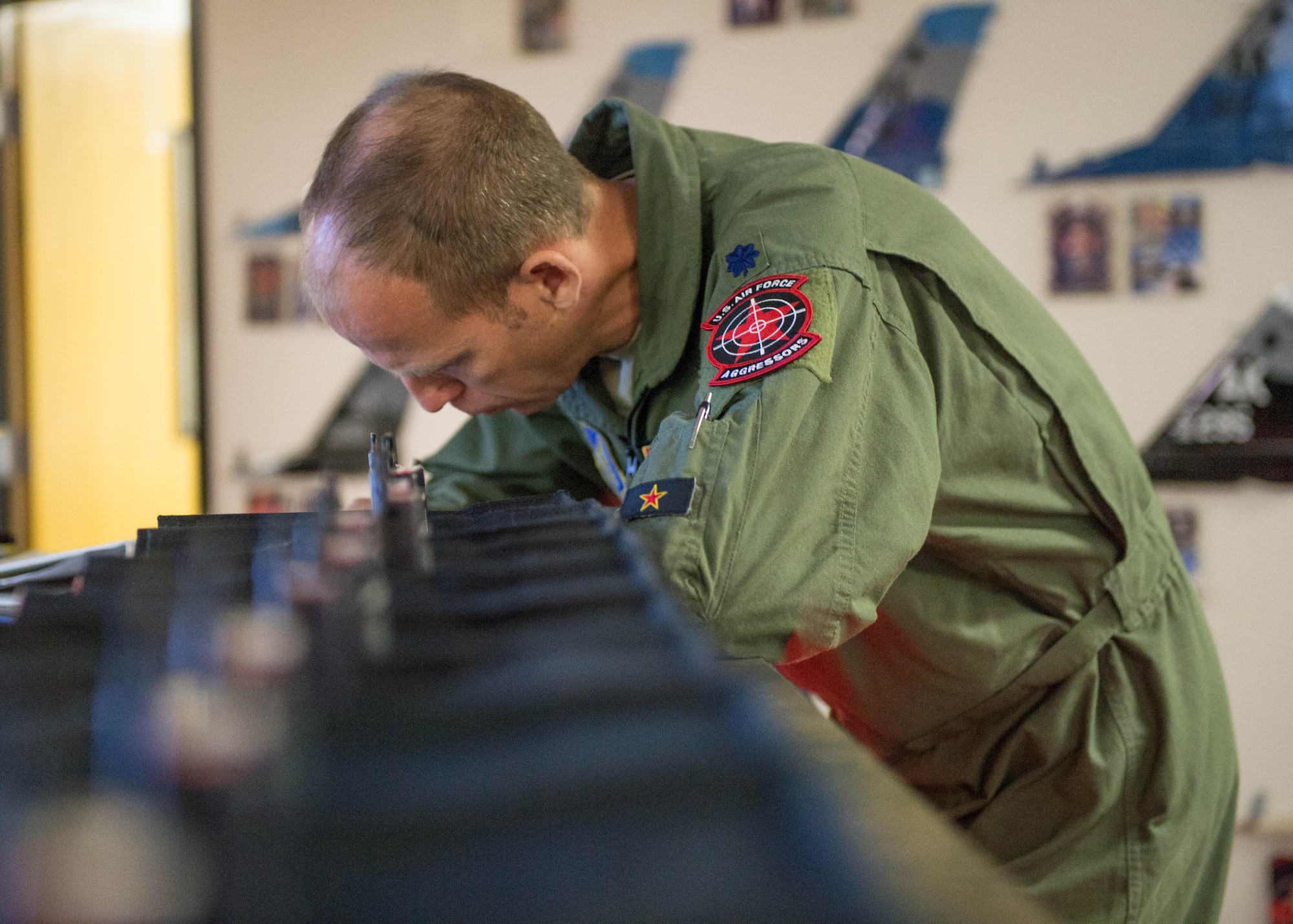 U.S. Air Force Lt. Col. Micah Bell, the 354th Operations Support Squadron commander, fills out flight paperwork at the 18th Aggressor Squadron operations desk prior to a a sortie June 14, 2016, during RED FLAG-Alaska (RF-A) 16-2 at Eielson Air Force Base, Alaska. Pilots from Eielson take on the role of Red Air “bad guys” during large scale exercises and train Blue Air pilots during RF-A. (U.S. Air Force photo by Staff Sgt. Shawn Nickel/Released)

