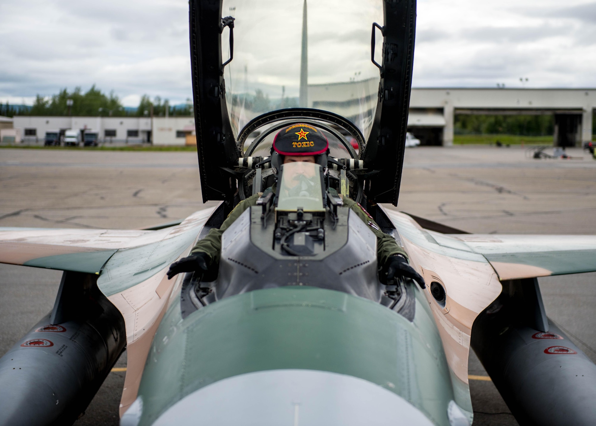 U.S. Air Force Maj. Brian Bragg, the 18th Aggressor Squadron assistant director of operations, waits with his hand in a safe position while crew chiefs from the 354th Aircraft Maintenance Squadron prepare the F-16 Fighting Falcon fighter aircraft to take off as a “bad guy” for a sortie June 14, 2016, during RED FLAG-Alaska (RF-A) 16-2 at Eielson Air Force Base, Alaska. The average Aggressor pilot has at least 1,000 fighter hours and hundreds of hours of studying to become experts in enemy tactics used to train U.S. Air Force, joint and coalition partners during the U.S. Pacific Air Forces commander-directed RF-A exercise. (U.S. Air Force photo by Staff Sgt. Shawn Nickel/Released)
