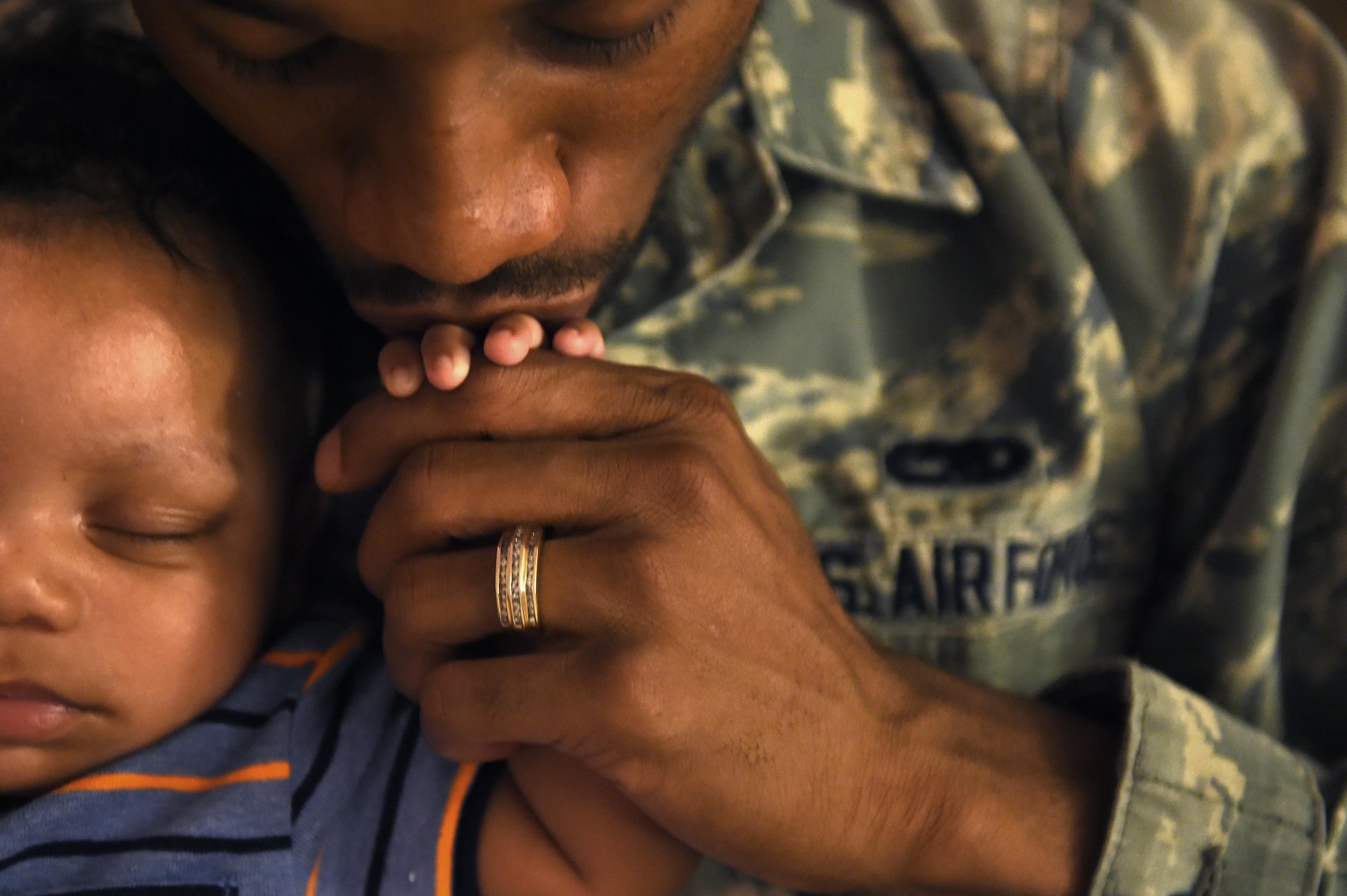 Senior Airman Edduard, a 49th Maintenance Squadron aircraft structural maintenance technician from Holloman Air Force Base, N.M., kisses his son’s hand while he naps in their home, June 15. As a new father, Edduard will be celebrating his first Father’s Day this year. (Last names are being withheld due to operational requirements. U.S. Air Force photo by Staff Sgt. Eboni Prince)