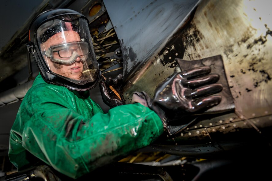 An Airmen from the 2nd Maintenance Squadron cleans a blast track during a pre-phase inspection wash at Barksdale Air Force Base, La., June 15, 2016. A team with over 15 Airmen took 14 hours to complete the jet wash, preparing it for a phase inspection.  (U.S. Air Force photo/Senior Airman Mozer O. Da Cunha)