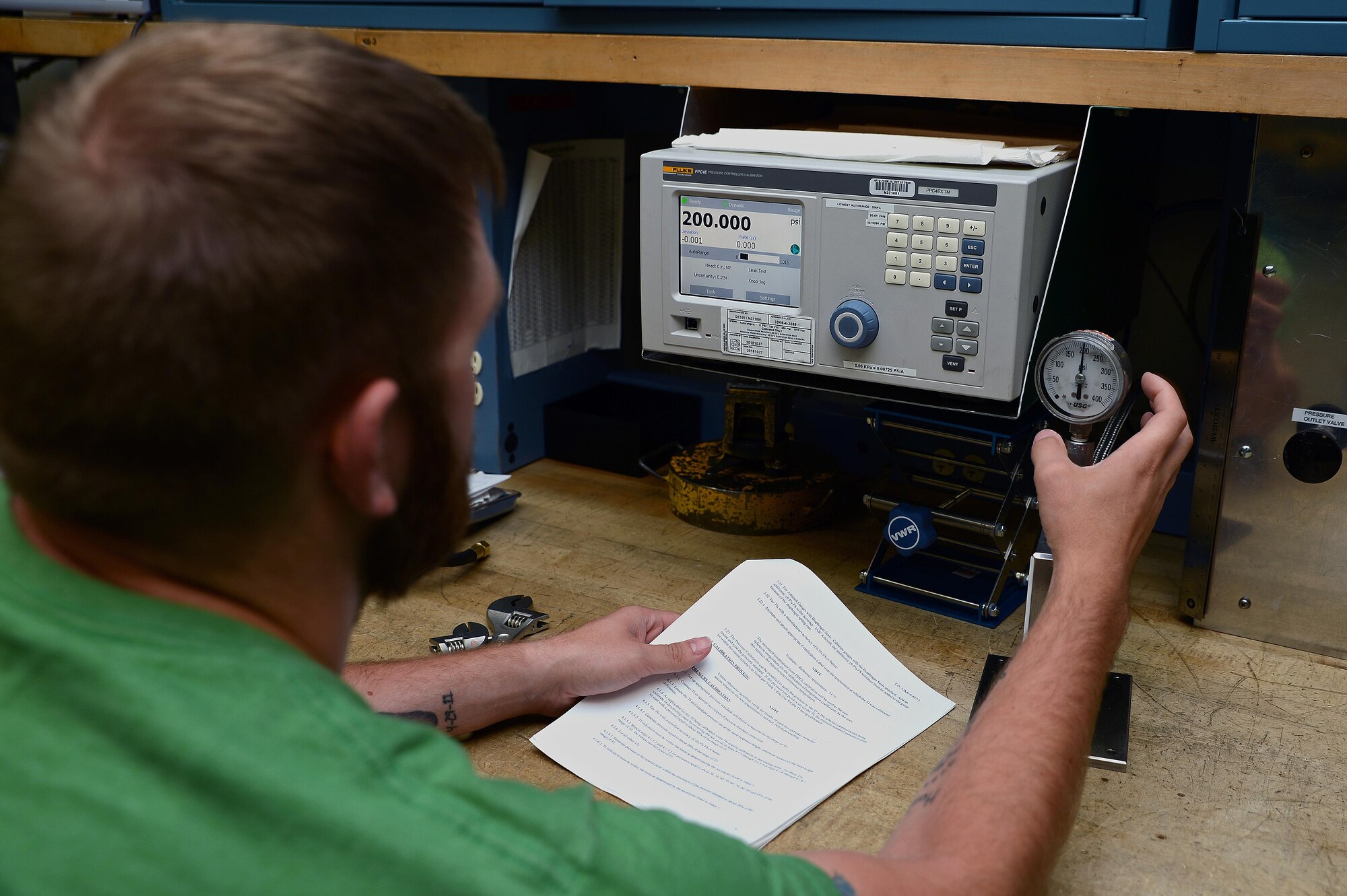 Sean Stone, 62nd Maintenance Squadron precision measurement equipment laboratory technician, calibrates a pressure gauge June 7, 2016 at Joint Base Lewis-McChord, Wash. The PMEL shop takes measurements in increments as small as millionths to ensure equipment is properly and calibrated and safe to use. (U.S. Air Force photo/Senior Airman Jacob Jimenez)   