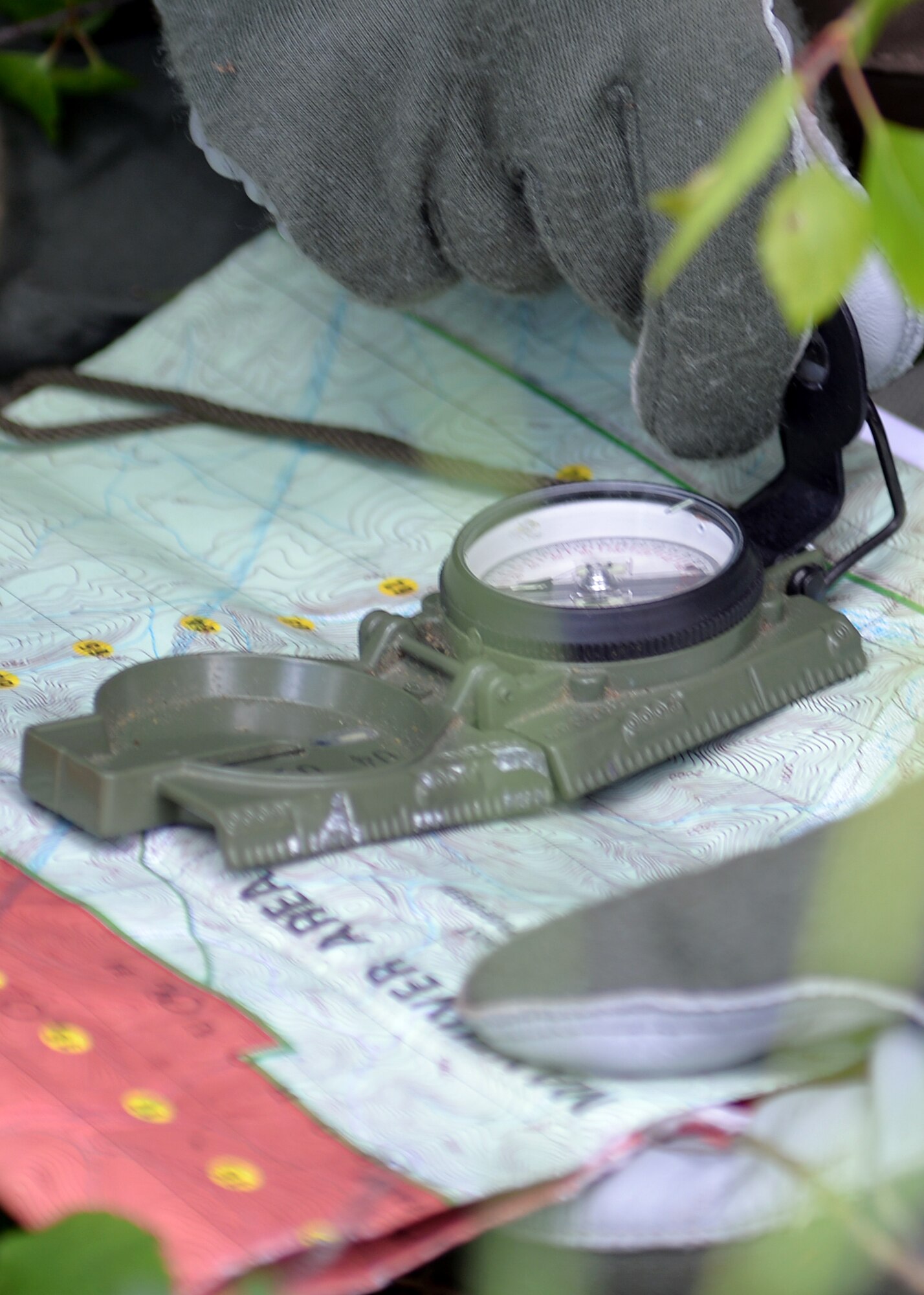 Capt. Keli Kaaekuahiwi, an A-10 pilot assigned to the 354th Fighter Squadron out of Davis-Monthan Air Force Base, Ariz., aligns his compass and map during a personnel recovery exercise at a training site in the Joint Pacific Alaska Range Complex (JPARC), June 14, 2016, during RED FLAG-Alaska (RF-A) 16-2. The JPARC provides a realistic training environment and allows commanders to train for full spectrum engagements, ranging from individual skills, such as isolated personnel evading capture, to complex, large-scale joint engagements. (U.S. Air Force photo by Master Sgt. Karen J. Tomasik/Released)