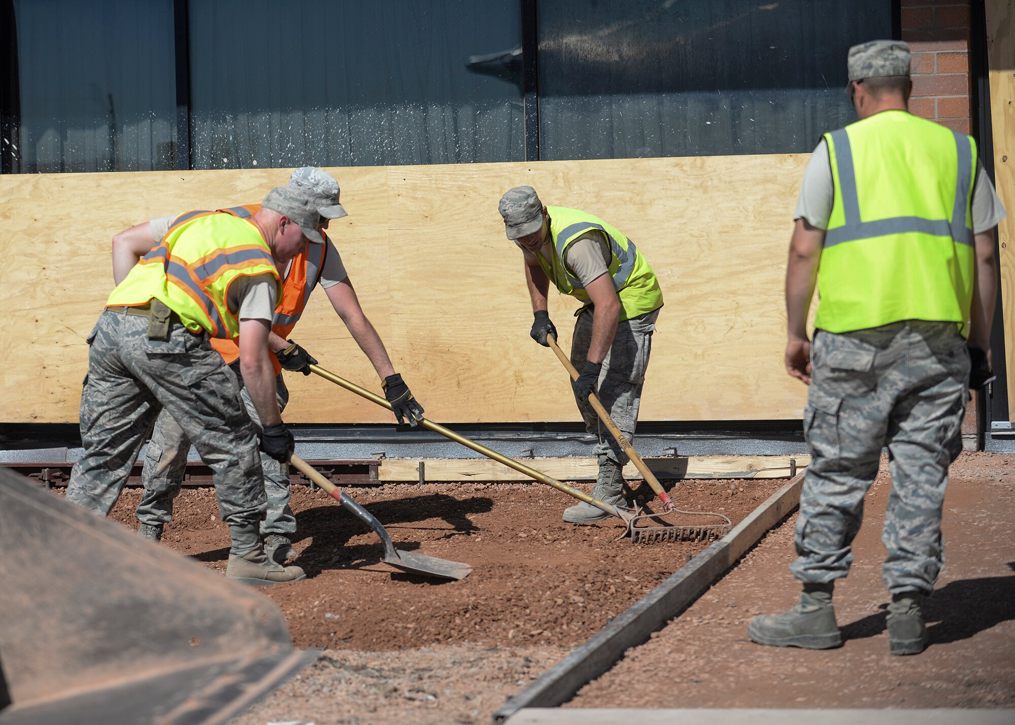 Airmen from the 28th Civil Engineer Squadron smooth down base course to prepare for the laying down of cement in front of the Holbrook Library at Ellsworth Air Force Base, S.D., June 16, 2016. As part of a renovations project, the base library will be getting new paved sidewalks in addition to a new patio for its patrons to enjoy during their visits. (U.S. Air Force photo by Senior Airman Anania Tekurio/Released)