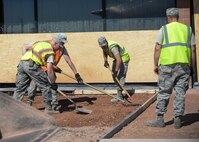Airmen from the 28th Civil Engineer Squadron smooth down base course to prepare for the laying down of cement in front of the Holbrook Library at Ellsworth Air Force Base, S.D., June 16, 2016. As part of a renovations project, the base library will be getting new paved sidewalks in addition to a new patio for its patrons to enjoy during their visits. (U.S. Air Force photo by Senior Airman Anania Tekurio/Released)