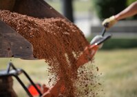 Base course, a soil support layer, is poured in preparation for the laying down of cement in front of the Holbrook Library at Ellsworth Air Force Base, S.D., June 16, 2016. Thirty tons of base course was used to build new sidewalks as part of a renovations project for the base library. (U.S. Air Force photo by Senior Airman Anania Tekurio/Released)