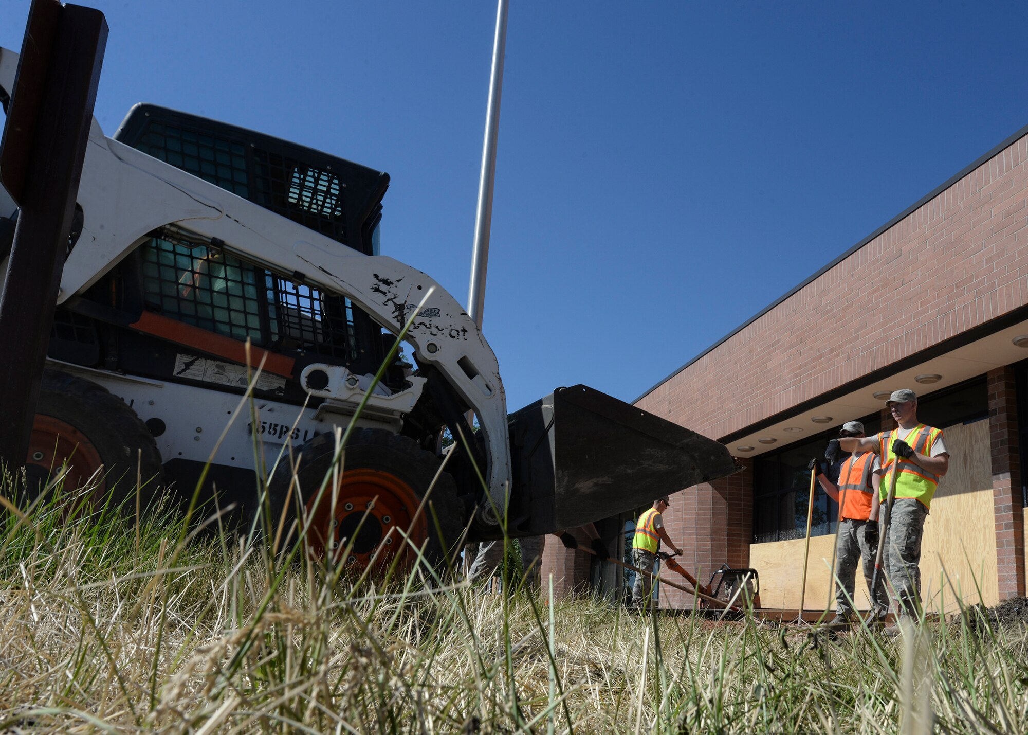 Staff Sgt. Dustin Snyder, 28th Civil Engineer Squadron hazardous material custodian, directs the dumping of the base course, a soil support layer, as part of a renovations project for the Holbrook Library at Ellsworth Air Force Base, S.D., June 16, 2016. In addition to new sidewalks, the library will also be getting a new patio built for its patrons to enjoy during their visits. (U.S. Air Force photo by Senior Airman Anania Tekurio/Released) 
