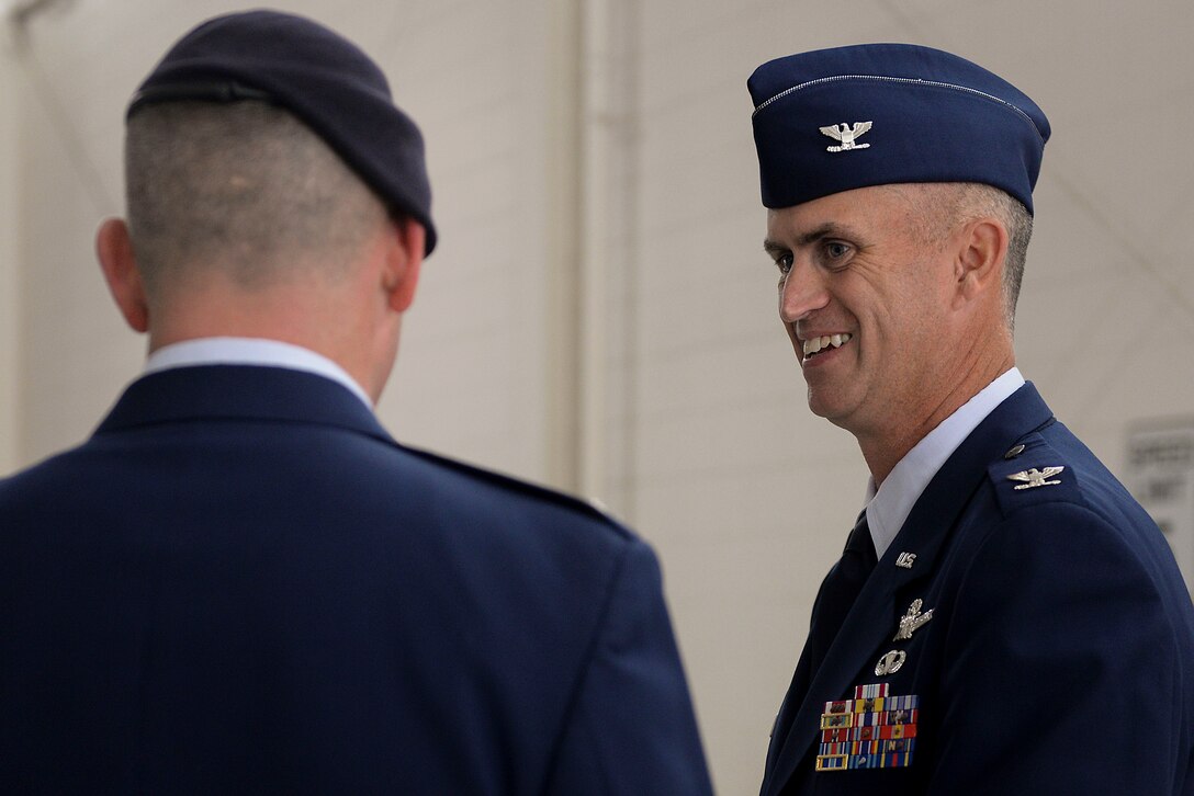 Col. Colin Connor, commander of the 91st Missile Wing, speaks with an Airman immediately following the 91st MW change of command ceremony June 17, 2016. Connor accepted command of the 91st MW from Col. Michael Lutton. (U.S. Air Force photo/Airman 1st Class Jessica Weissman)