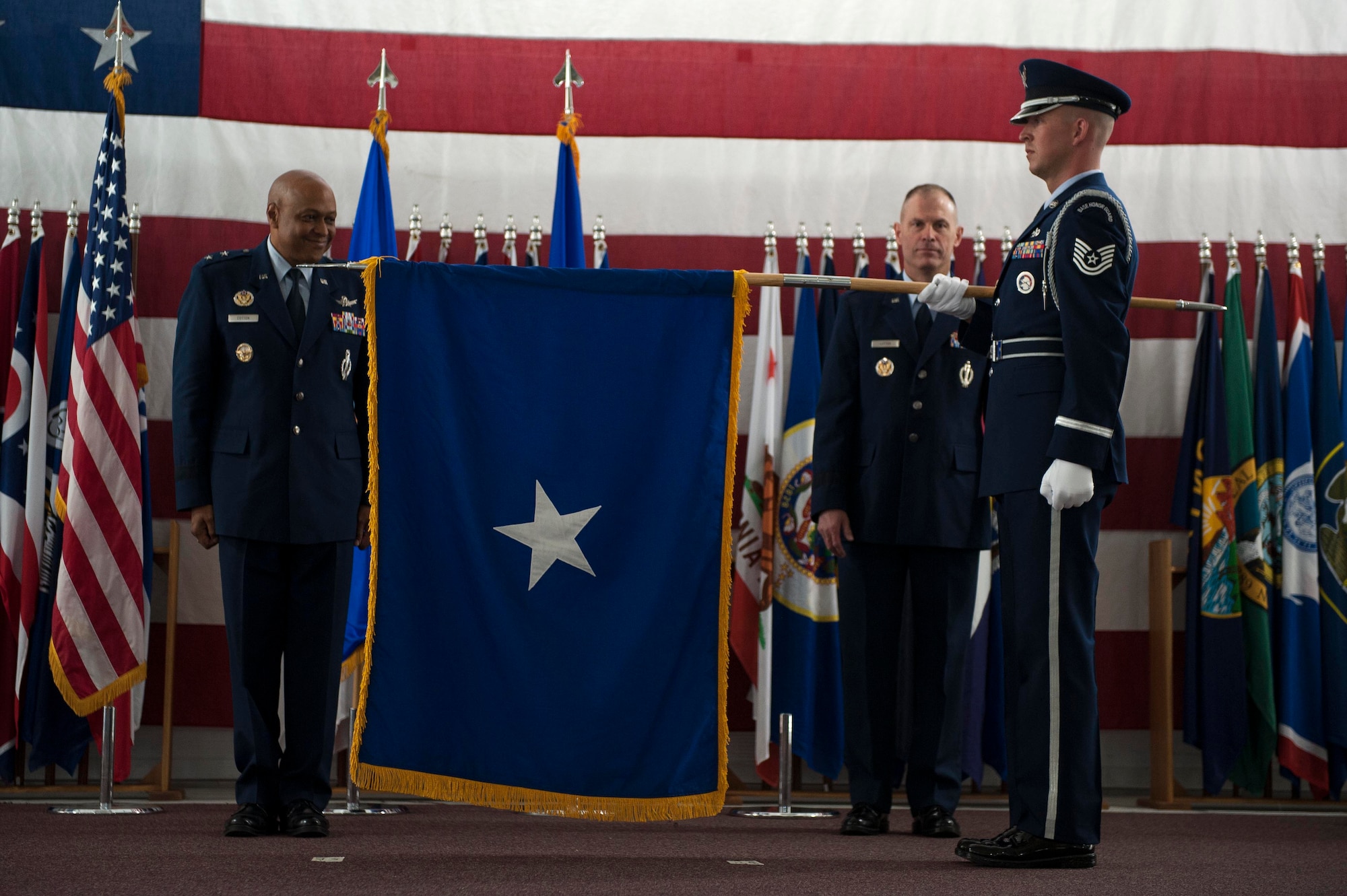 New Brig. Gen. Michael Lutton, who is headed to the Pentagon to work with the Department of Energy, is presented his Brig. Gen. flag by Tech. Sgt. Joshua Hull, non-commissioned officer in charge of Base Honor Guard, at Minot Air Force Base, N.D., June 17, 2016. The presentation of the General flag is an Air Force tradition. (U.S. Air Force photo/Senior Airman Kristoffer Kaubisch) 