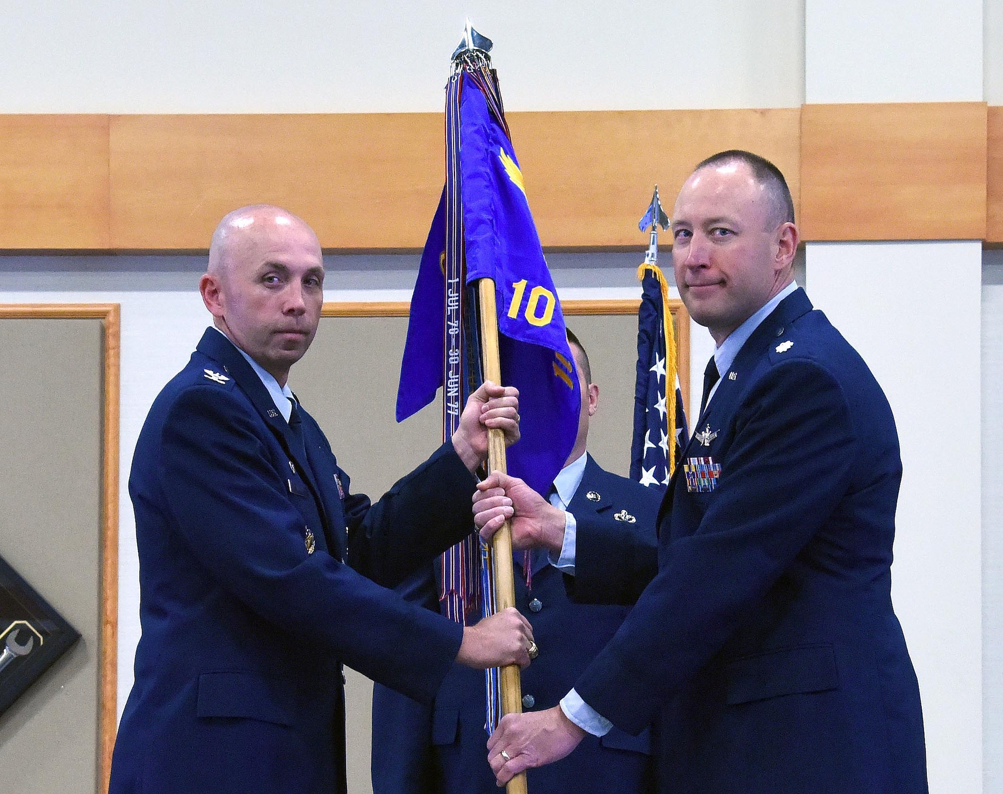 Lt. Col. Mark Kasayka, right, accepts command of the 10th Missile Squadron from Col. Ron Allen, 341st Missile Wing commander, during a change of command ceremony at the Malmstrom Air Force Base Grizzly Bend June 17. Master Sgt. Jason Wintersteen, NCO in charge facility manager, looks on. (U.S. Air Force photo/Senior Airman Jaeda Tookes)