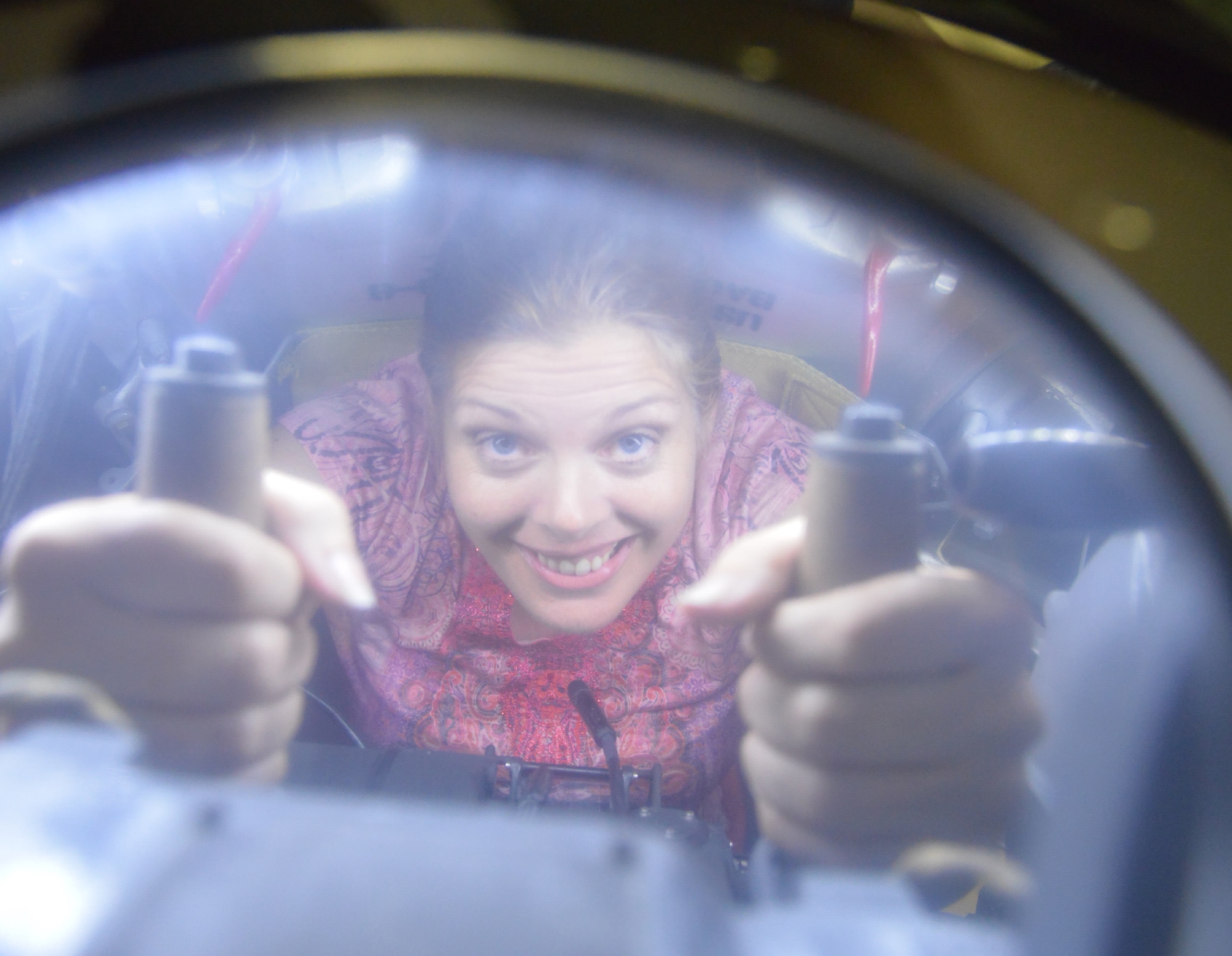 Angela Woolen, Robins Rev-Up staff writer, shows how tight the quarters were for the B-17 ball turret gunner. (U.S. Air Force photo by Ray Crayton)