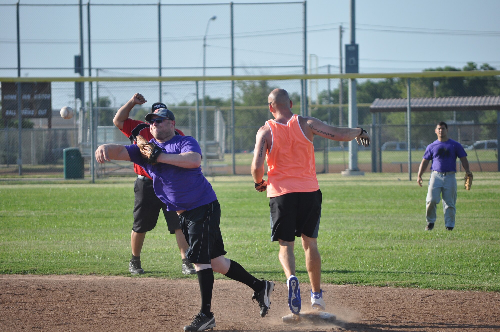 552 ACNS player Mahlon Crossley throws to home June 7 after nabbing a second base out on NGC player Joseph Rippinger. The Northrop Grumman Corp. team won the close game 16-15 at softball Field No. 1 north of the dorms. (Air Force photo by John Parker)