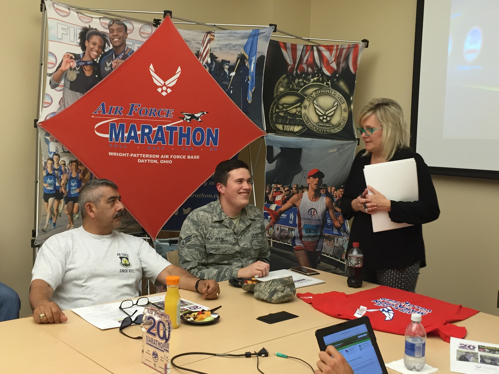 Master Sgt. Antonio Ruiz, Tecumseh High School Air Force JROTC advisor, and Senior Airman Andrew Felix, National Air and Space Intelligence Center, attend the 2016 Air Force Marathon Lead Volunteer Kickoff at the Indu and Raj Soin Medical Center June 8. Leading the meeting is Jeanette Monaghan, Air Force Marathon volunteer coordinator. Ruiz will serve as race day baggage claim coordinator, while Felix plans to volunteer as expo set-up and race day tear-down coordinator. 
(Skywrighter photo/Amy Rollins)
