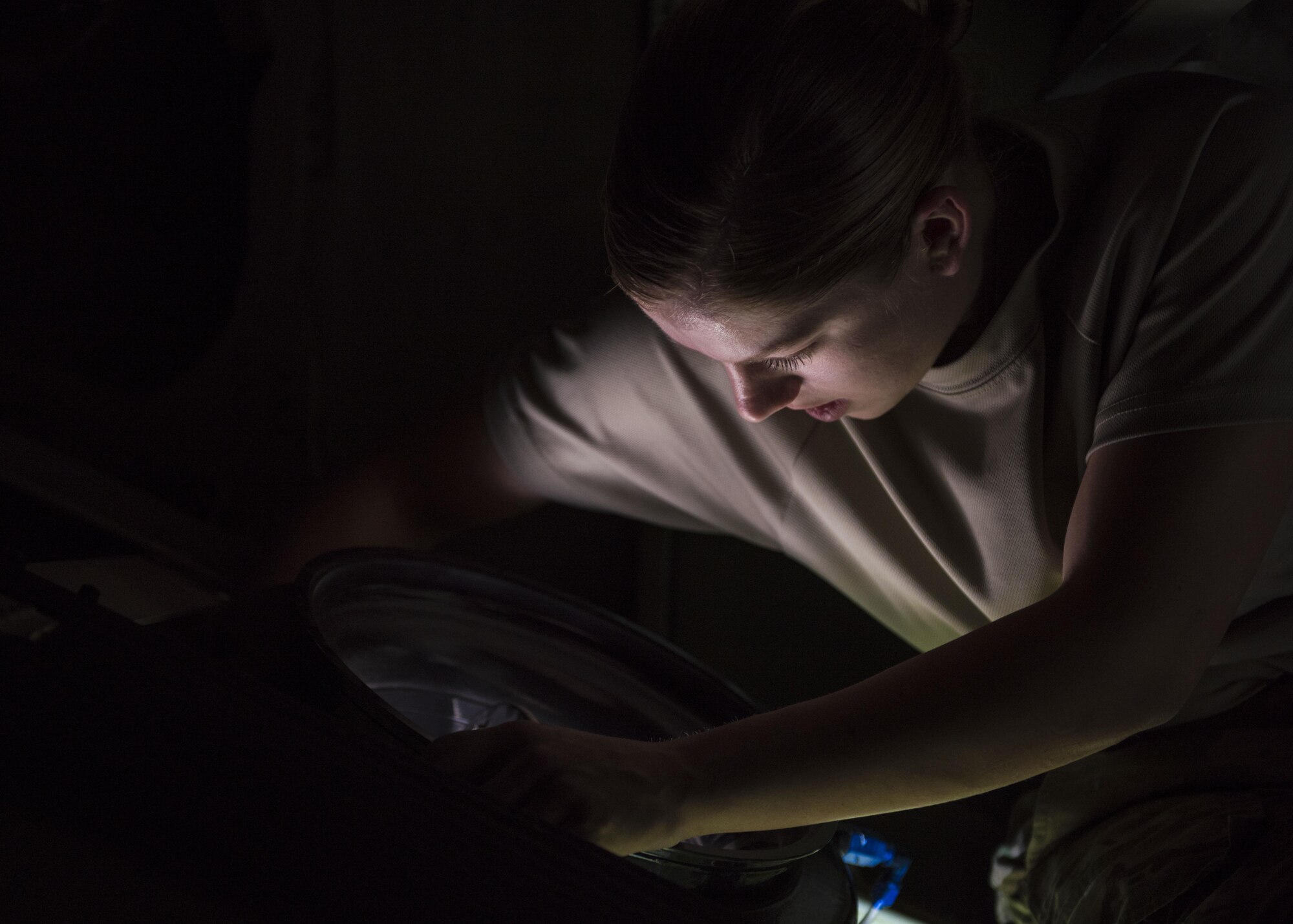 Senior Airman Ashley Frey, 455th Expeditionary Aircraft Maintenance Squadron crew chief, looks through a hole of a C-130J Super Hercules, June 15, 2016, Bagram Airfield, Afghanistan. The 455th EAMXS is responsible for repairing and maintaining military aircraft, as well as performing preventative maintenance inspections. (U.S. Air Force photo by Senior Airman Justyn M. Freeman)