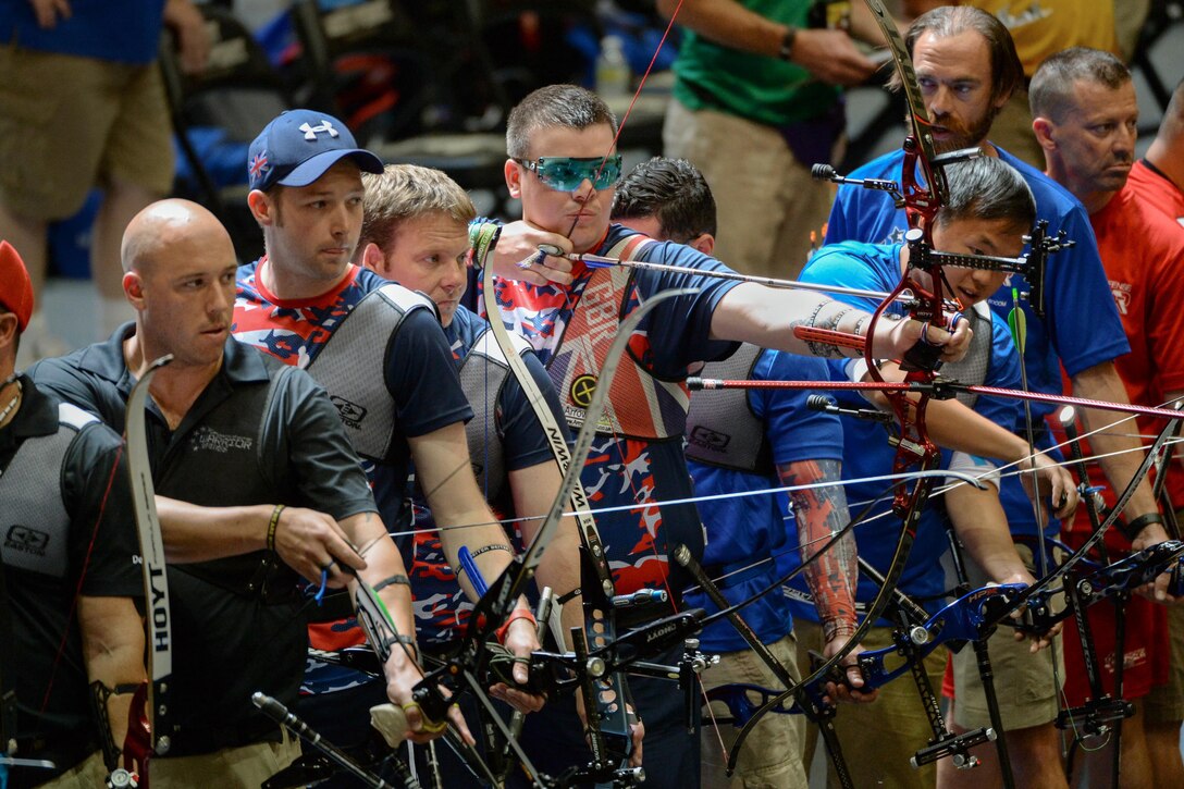 British Rifleman David Cousins, center, of the United Kingdom archery team draws his bow in a line of archers during the 2016 Department of Defense Warrior Games at the U.S. Military Academy in West Point, N.Y., June 17, 2016. DoD photo by EJ Hersom