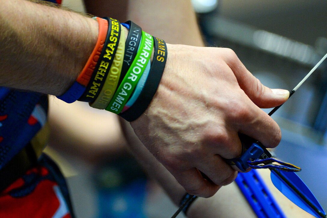 A British athlete wearing colorful wrist bands draws his bow during the 2016 Department of Defense Warrior Games at the U.S. Military Academy in West Point, N.Y., June 17, 2016. DoD photo by EJ Hersom
