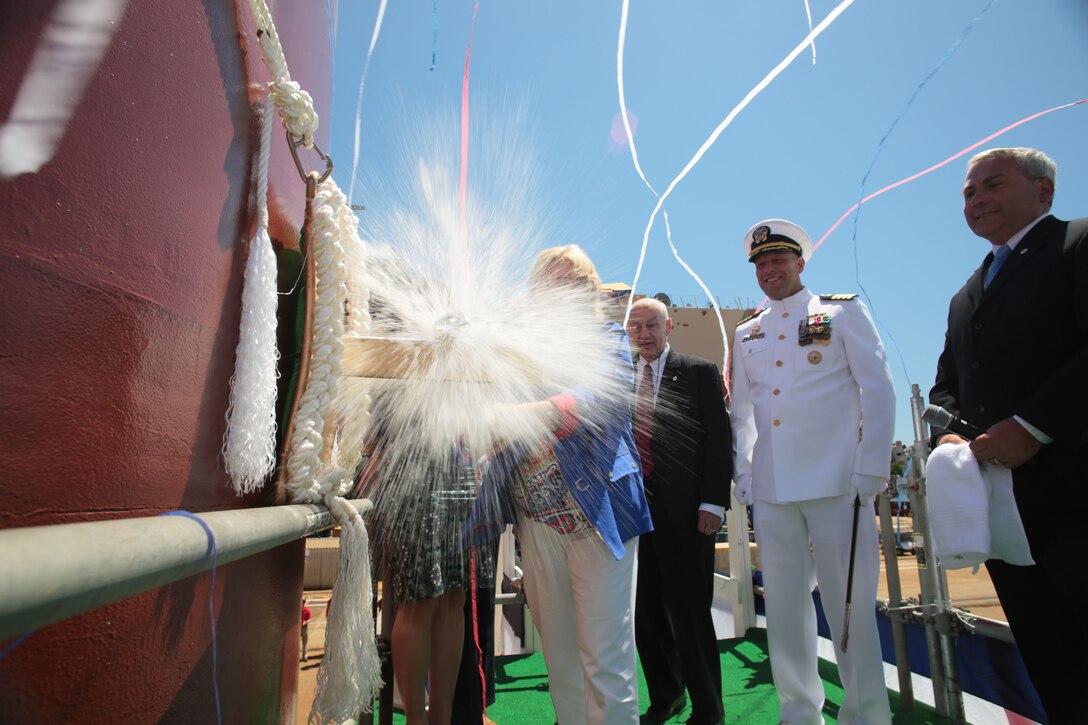 Sally Monsoor christens the future USS Michael Monsoor, named in honor of her son, Medal of Honor recipient Navy Petty Officer 2nd Class Michael A. Monsoor in Bath, Maine, June 18, 2016. The Michael Monsoor is the second ship in the Zumwalt-class of destroyers and will serve as a multi-mission platform capable of operating as an integral part of naval, joint or combined maritime forces. Navy photo courtesy Bath Iron Works