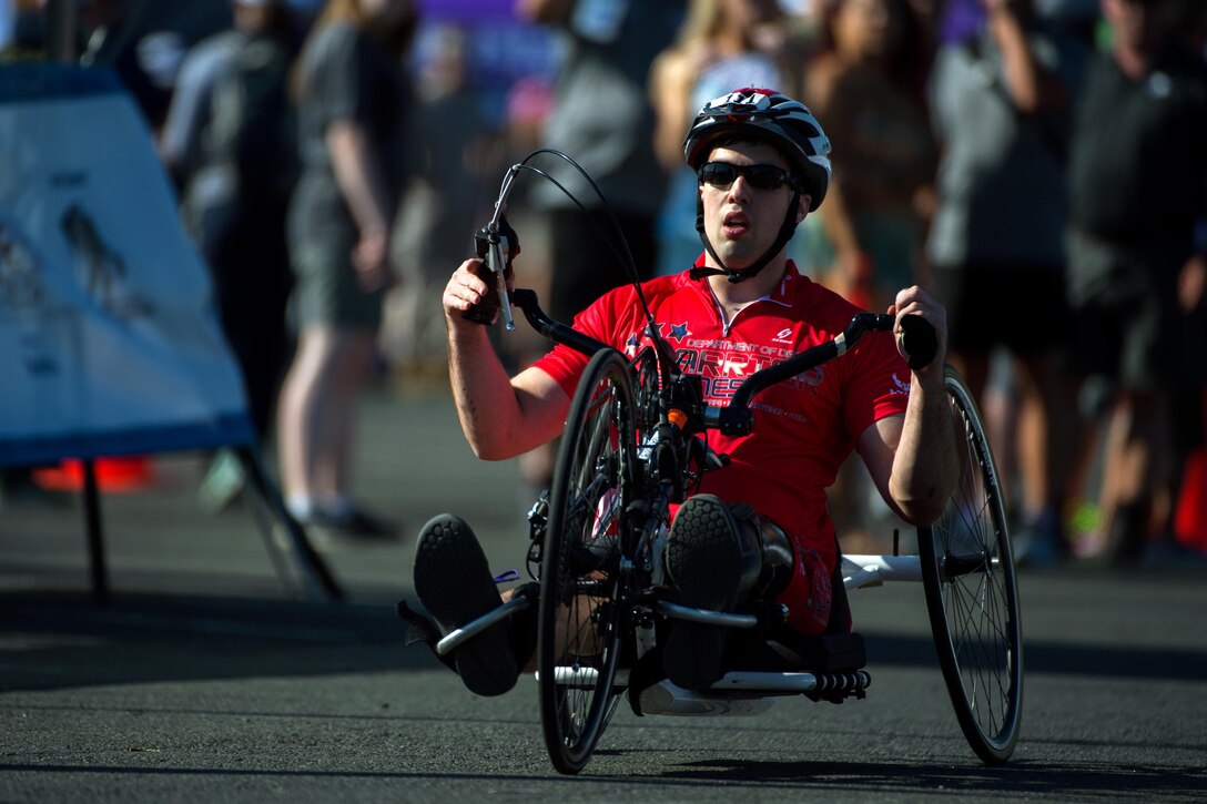 Marine Corps 2nd Lt. Anthony Kemp powers a hand cycle across the finish line of the 2016 Department of Defense Warrior Games cycling course at  the U.S. Military Academy in West Point, N.Y., June 18, 2016. DoD photo by EJ Hersom