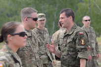 Polish Army Pfc. Mircim Jasek, a translator, with 1st Warsaw Armored Brigade in Warsaw, Poland, translates instructions to U.S. Army Sgt. Joseph Pischieri, a medic with the 30th Medical Brigade, located in Wiesbaden, Germany during a marksmanship competition with Polish Army Soldiers, using Polish weapons at the Warszawska Brygada Pancerna Range in Warsaw, Poland, May 28.