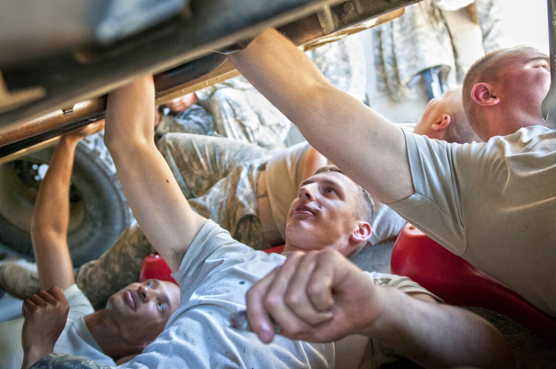 Spc. Eric Sander, a wheeled vehicle mechanic with the 254th Quartermaster Company, (center), works on a Humvee during the annual U.S. Army Reserve Quartermaster Liquid Logistics Exercise (QLLEX) at Fort. A.P. Hill, Va., June 18, 2016. (U.S. Army photo by Staff Sgt. Dalton Smith/Released)