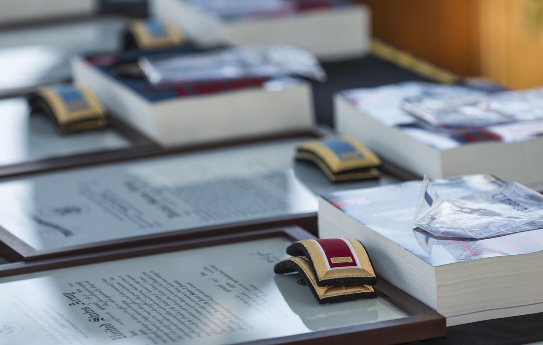 A stack of second lieutenant ranks, Army Officer Guides and framed commissioning decrees are placed on a table for six lieutenants about to commission into the U.S. Army among hundreds of Kings Pointers at the U.S. Merchant Marine Academy in Kings Point, New York, during a private commissioning ceremony June 18. Maj. Gen. Phillip Churn, commanding general of the 200th Military Police Command, U.S. Army Reserve, a native of Washington, D.C., administered the Oath of Commissioned Officers for the Army lieutenants. The 2016 graduating class included 229 senior midshipmen, each earning a Bachelor of Science degree, a direct commission into the armed forces and a U.S. Coast Guard license. (U.S. Army photo by Master Sgt. Michel Sauret)