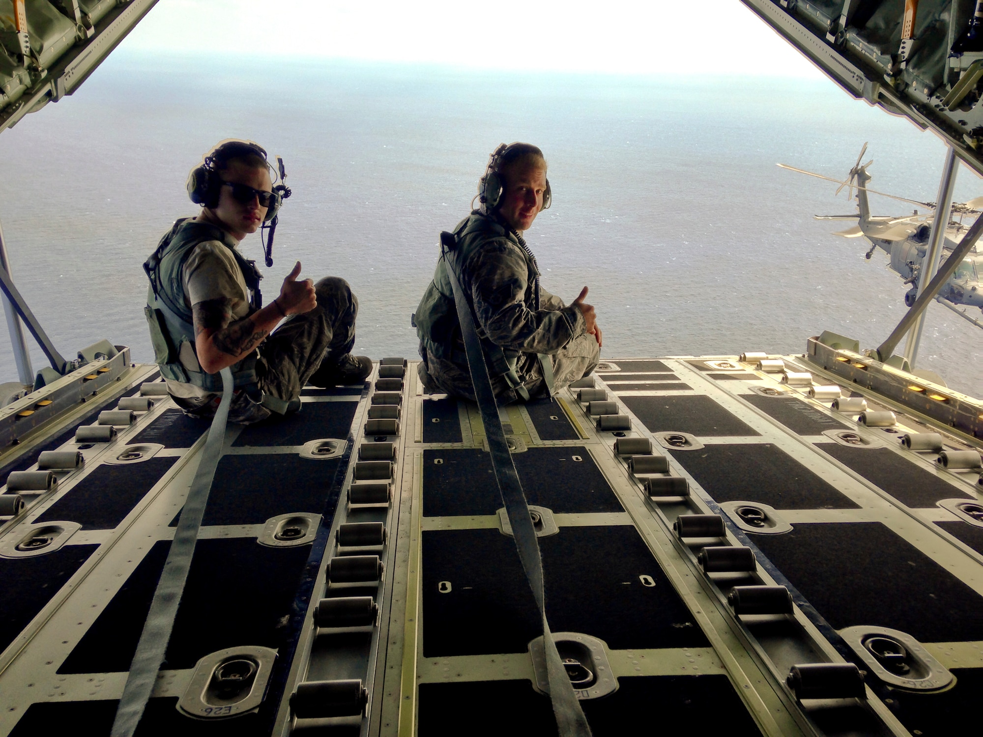 U.S. Air Force Senior Airman Shaun Smith and Staff Sgt. Jason Pitman, both 353rd Special Operations Maintenance Squadron MC-130J Commando II crew chiefs, observe in-flight refueling procedures over the Philippine Sea, April 2015. Smith and Pitman ensure around-the-clock readiness of MC-130J aircraft which can sortie at a moment's notice for support operations throughout the Indo-Asia-Pacific theater. (courtesy photo)