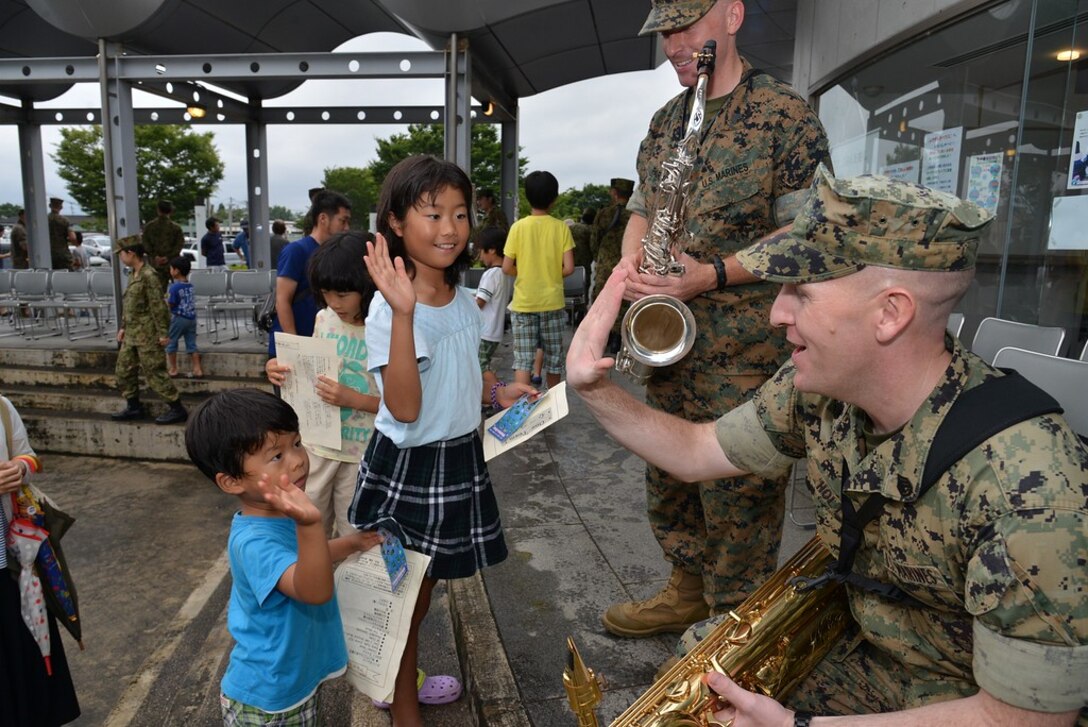 U.S. Marine Corps Staff Sgt. James R. Holt and Sgt. Michael A. Parker, musicians with the III Marine Expeditionary Force Band, interact with Japanese children, June 17-20, 2016, while performing for Japanese citizens displaced by an earthquake that struck Kumamoto, Japan, April 16, 2016. Musicians with the III MEF band performed alongside the 8th Division Band of Japan's Western Army. (Courtesy Photo/ Released)