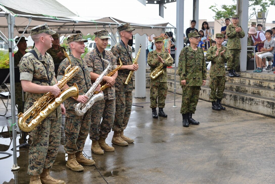 U.S. Marine Corps Staff Sgts. James R. Holt, Neil Z. Loaiza, Sgt. Michael A. Parker and Lance Cpl. Ivan E. Arden perform with Japan Western Army's 8th Division Band, June 17-20, 2016, in areas affected by the earthquake that struck Kumamoto, Japan, April 16, 2016. The Marines are musicians with the III Marine Expeditionary Force Band.