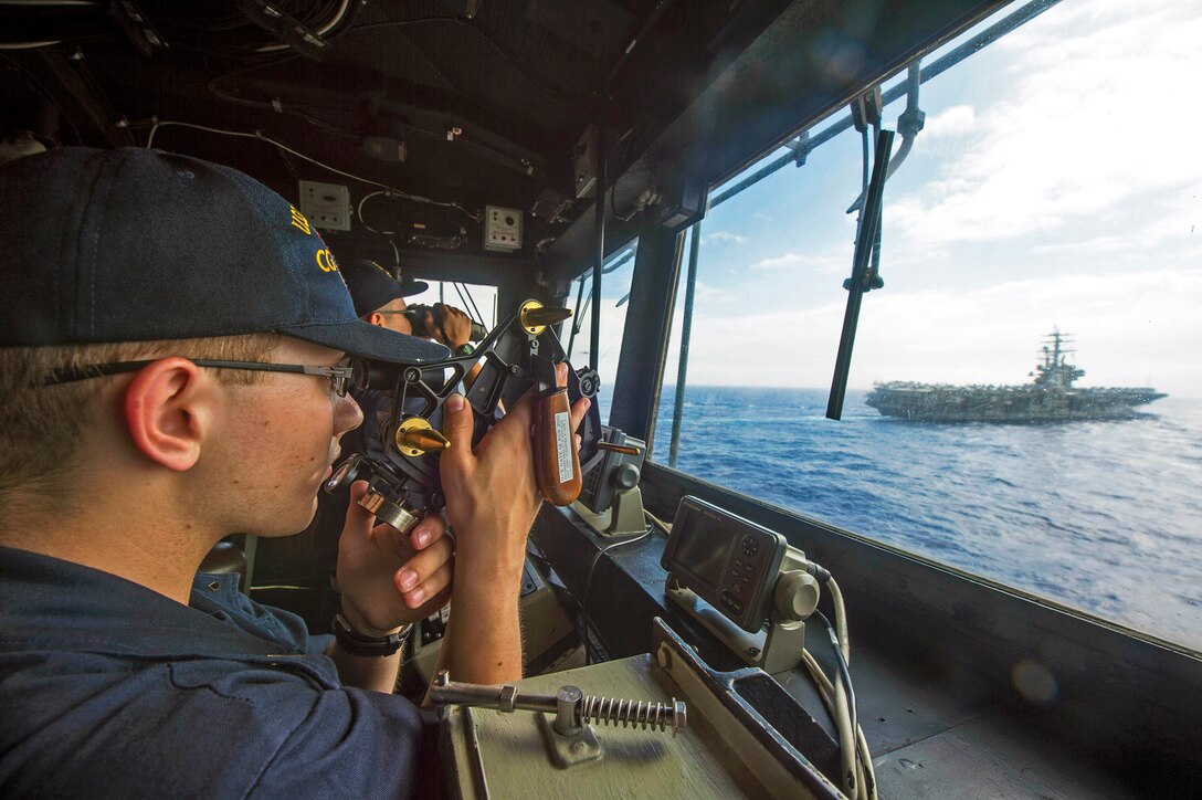 Navy Ensign Clayton Dietz takes ranges in the pilot house of the Ticonderoga class guided-missile cruiser USS Shiloh as the ship steams in formation with the Nimitz-class aircraft carriers USS Ronald Reagan and USS John C. Stennis  in the waters east of Japan, June 18, 2016. Navy photo by Petty Officer 3rd Class Alonzo M. Archer