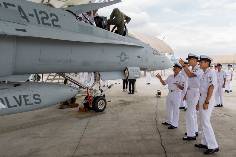 Japan Air Self-Defense Force aviation officer cadets from the Japan Maritime Self-Defense Force Ozuki Aviation Training Squadron observe and converse about an F/A-18C static display during a Japanese Officer Exchange Program tour at Marine Corps Air Station Iwakuni, Japan, June 17, 2016. Hosted by Marine Aircraft Group 12, the exchange program aims to better the understanding and working relationships between U.S. and Japanese pilots. The visit provides the cadets with greater knowledge and understanding of the present condition of the Marines in Japan. (U.S. Marine Corps photo by Lance Cpl. Aaron Henson/Released)