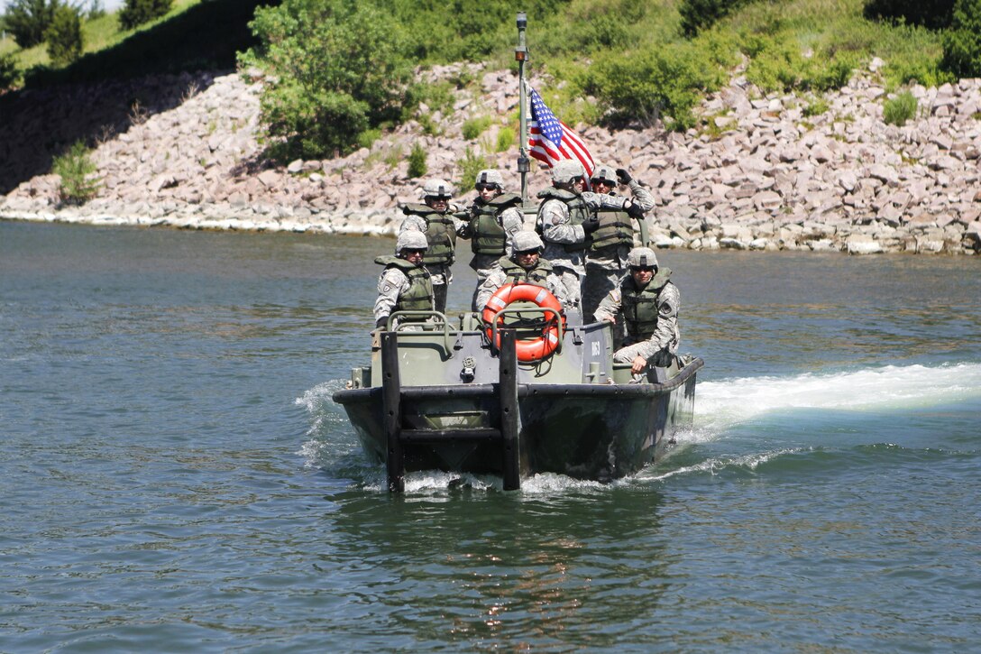 Army Sgt. Brandon LaBrie, foreground, observes Mk2 bridge erection boat operations in the Missouri River during Operation Golden Coyote near Chamberlain, S.D., June 10, 2016. LaBrie is a boat operator assigned to the South Dakota Army National Guard’s 200th Engineer Multi-Role Bridge Company. Army photo by Spc. Gary Silverman