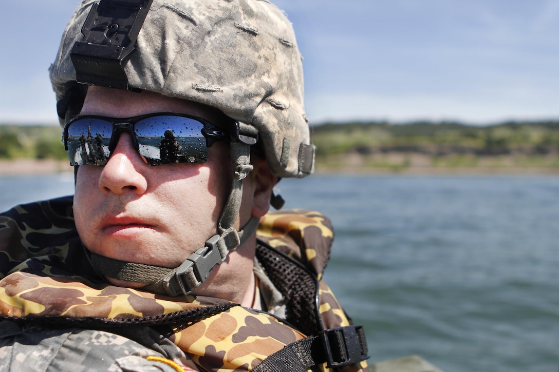 Army Sgt. Brandon LaBrie looks back while observing Mk2 bridge erection boat operations in the Missouri River during Operation Golden Coyote near Chamberlain, S.D., June 10, 2016. LaBrie is a boat operator assigned to the South Dakota Army National Guard’s 200th Engineer Multi-Role Bridge Company. Army photo by Spc. Gary Silverman
