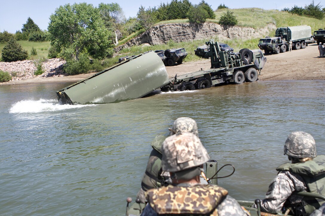Soldiers unload an improved ribbon bridge piece into the Missouri River during Operation Golden Coyote near Chamberlain, S.D., June 10, 2016. Army photo by Spc. Gary Silverman  